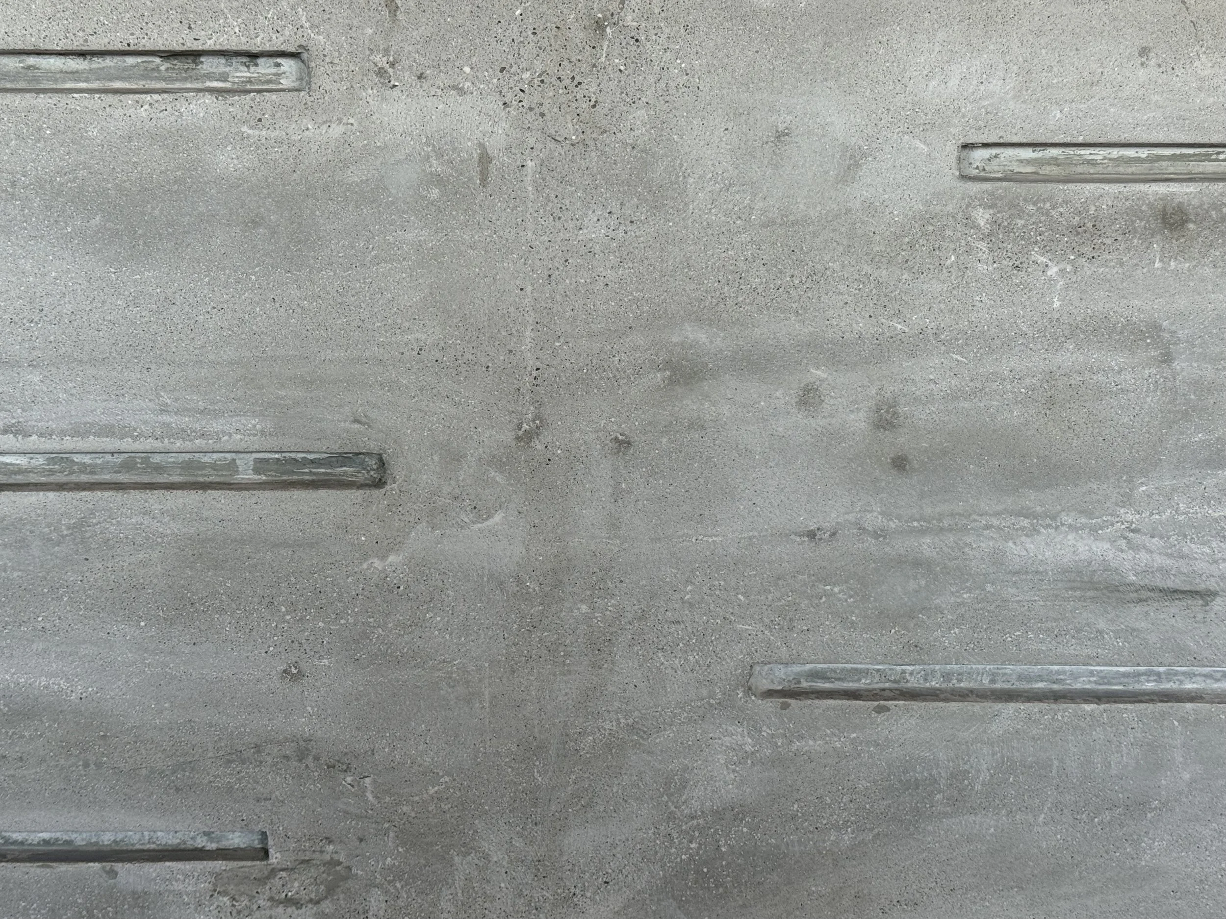 Concrete wall with embedded metal rails.