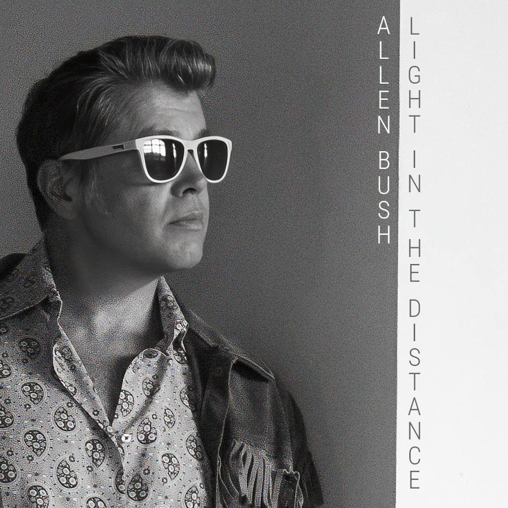 Black and white photo of Allen Bush wearing sunglasses and a patterned shirt, with a leather jacket draped over his shoulder, looking to the side. Text on the right side reads "Allen Bush" and "Light in the Distance."