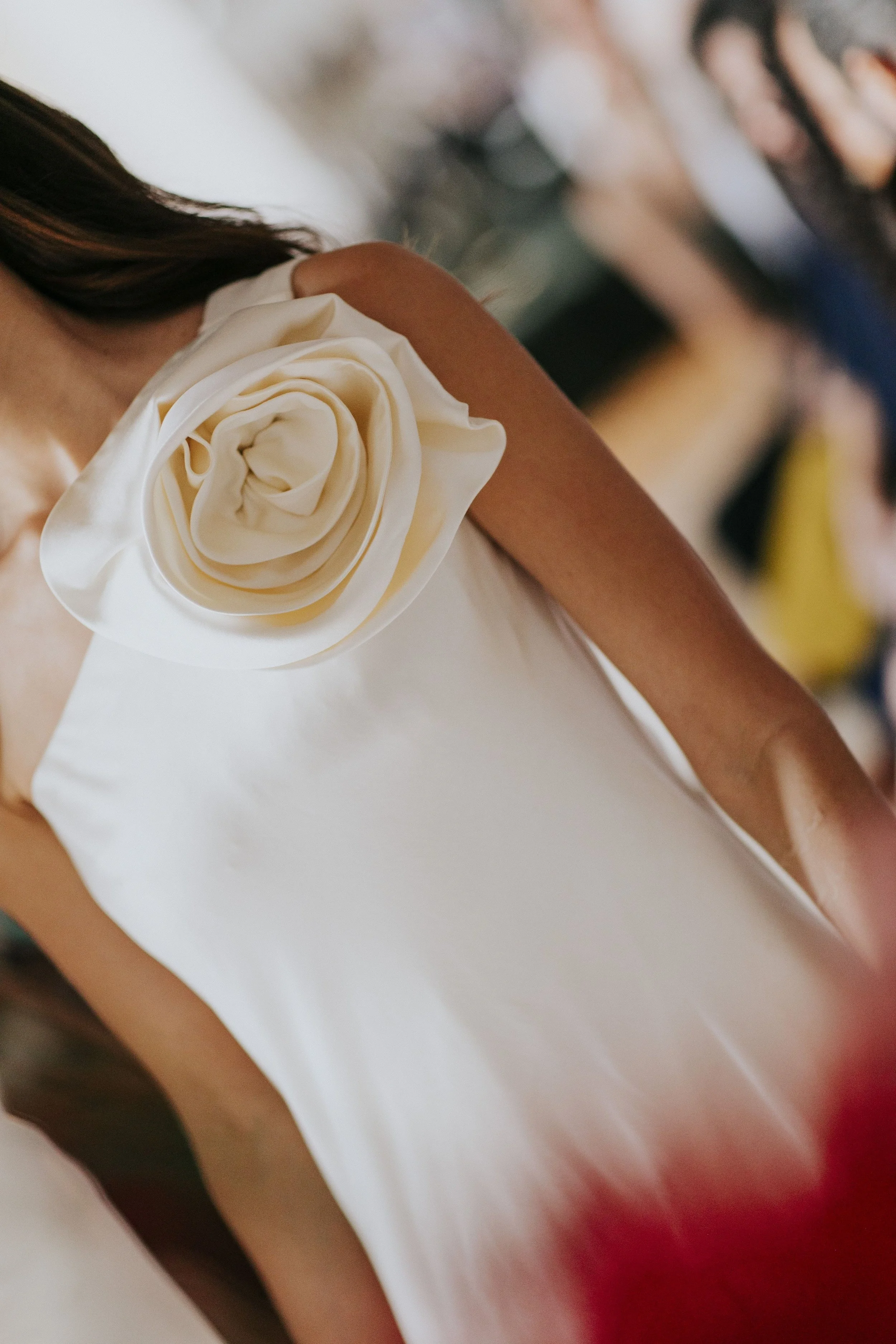 Pessoa usando vestido branco com flor de seda no ombro