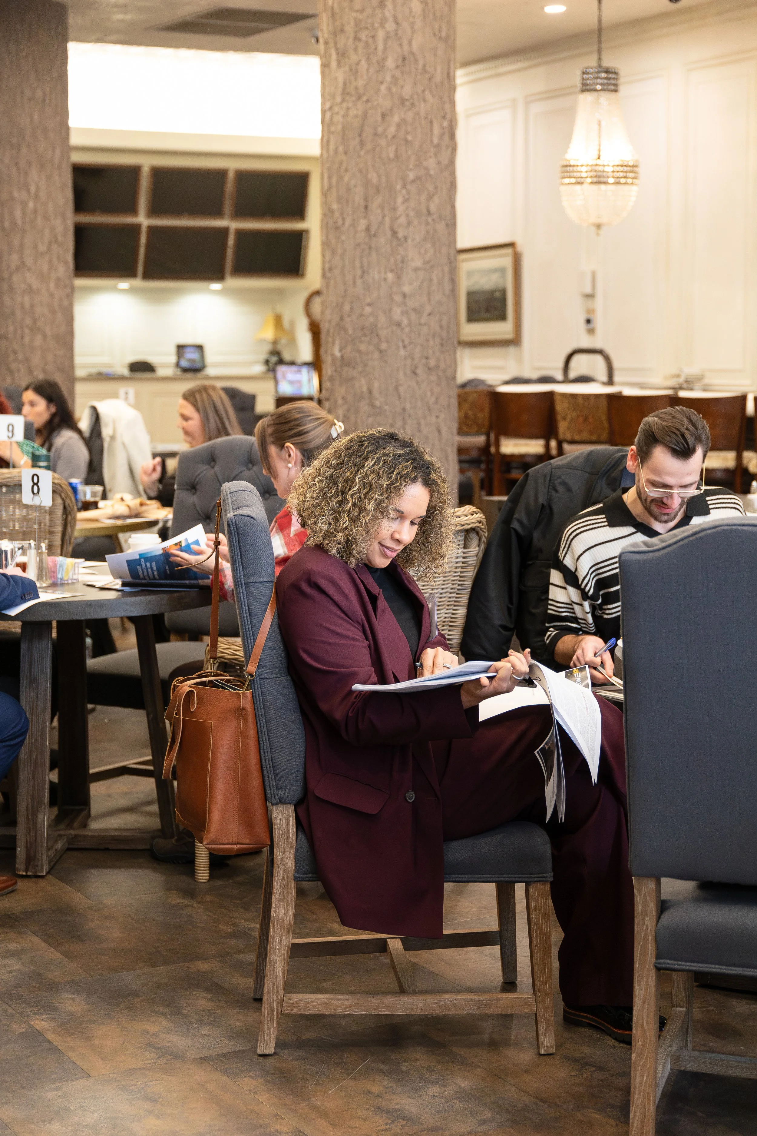 A woman flips through a stack of papers at a conference.