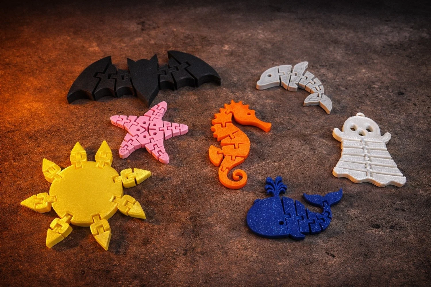 Colorful collection of 3D‑printed keychains featuring playful ocean creatures and celestial shapes