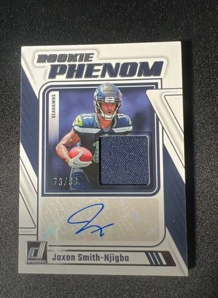 Sports trading card of rookie Seahawks football player Jaxon Smith-Njigba with a fabric swatch and autograph.