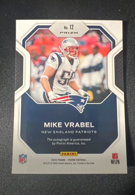 Football trading card of Mike Vrabel from the New England Patriots, labeled No. 12 PRIZM, featuring a photo of him in Patriots uniform, with team logo and information including his name and team, Nolfa and NFLPA logos, and copyright details.