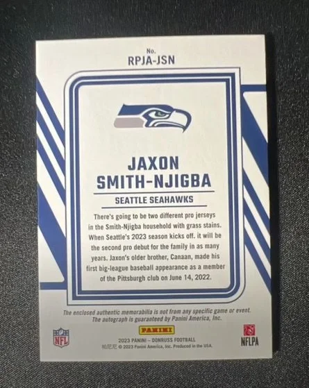 A Seattle Seahawks football card featuring Jaxon Smith-Njigba, with team logo, player's name, and a biography about his performance and debut.