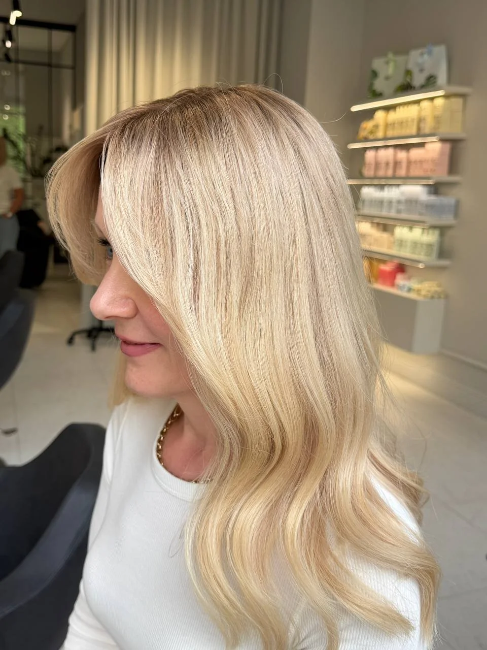 Side view of a woman with long, wavy blonde hair natural human hair wig
