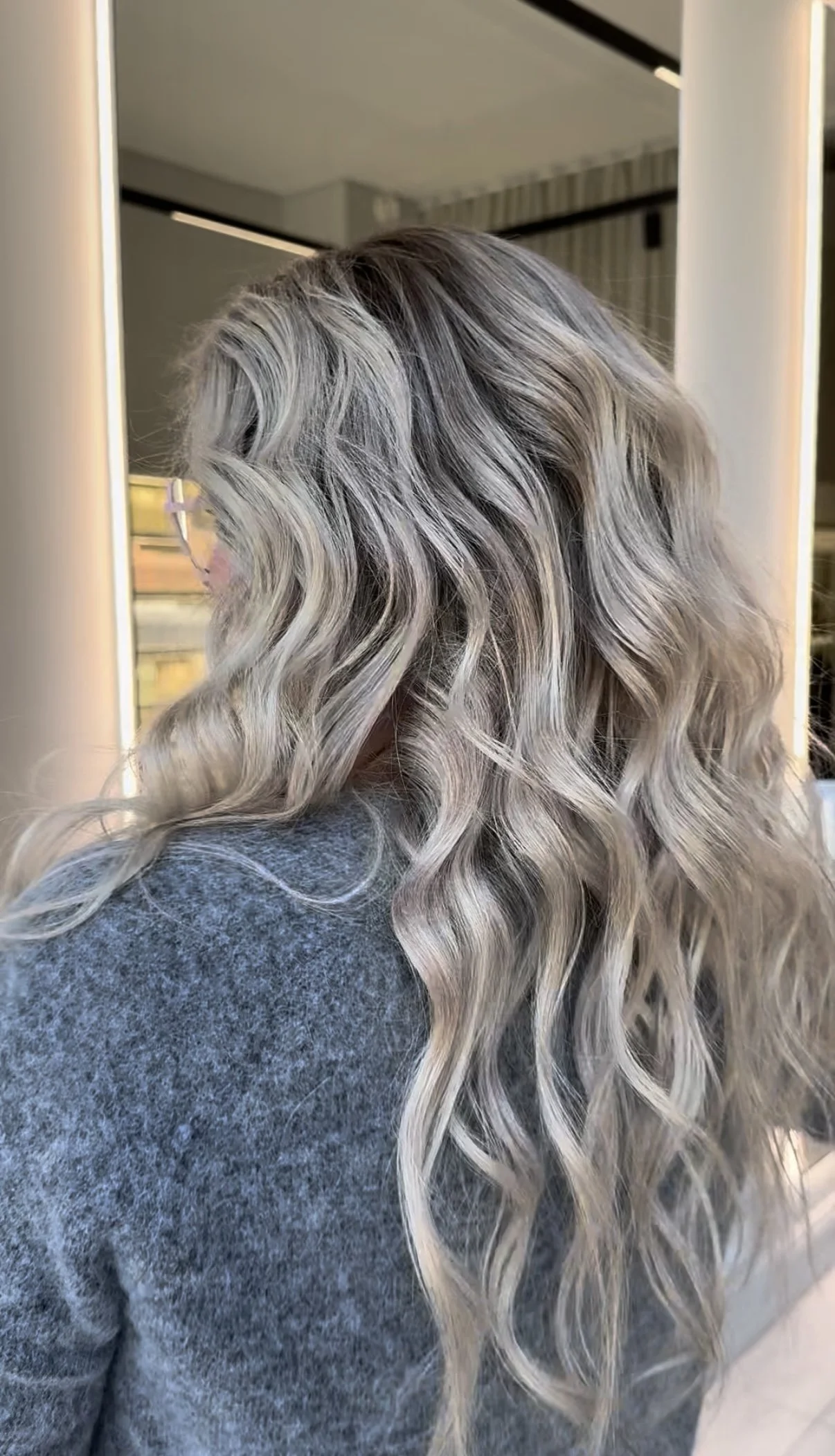 A woman with long, wavy, blonde human hair wig