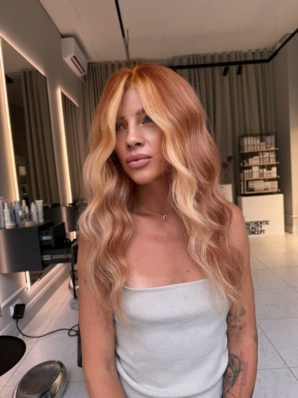 Woman with long wavy reddish blonde hair wig