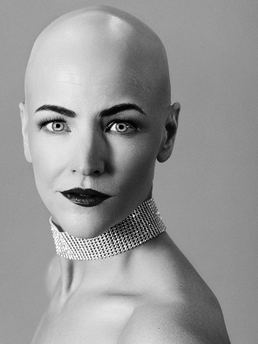 A black-and-white portrait of a bald woman 
