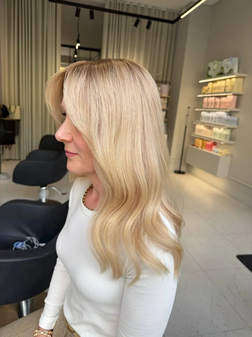 A woman with long, wavy blonde hair wig