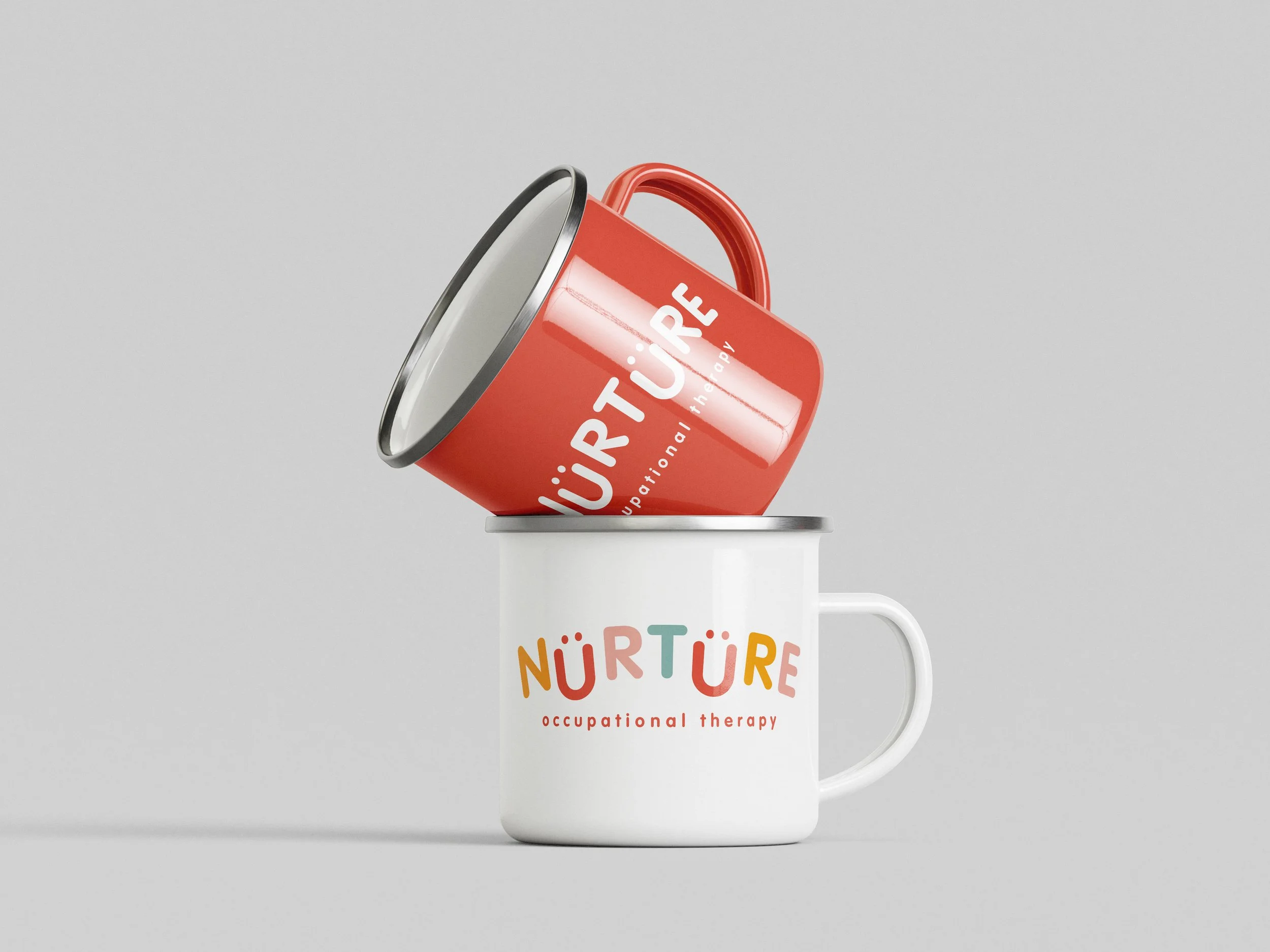 A white mug with colorful text that reads 'NURTURE occupational therapy' and two stacked cans, one red and one white, with the red one tilted inside the white mug.
