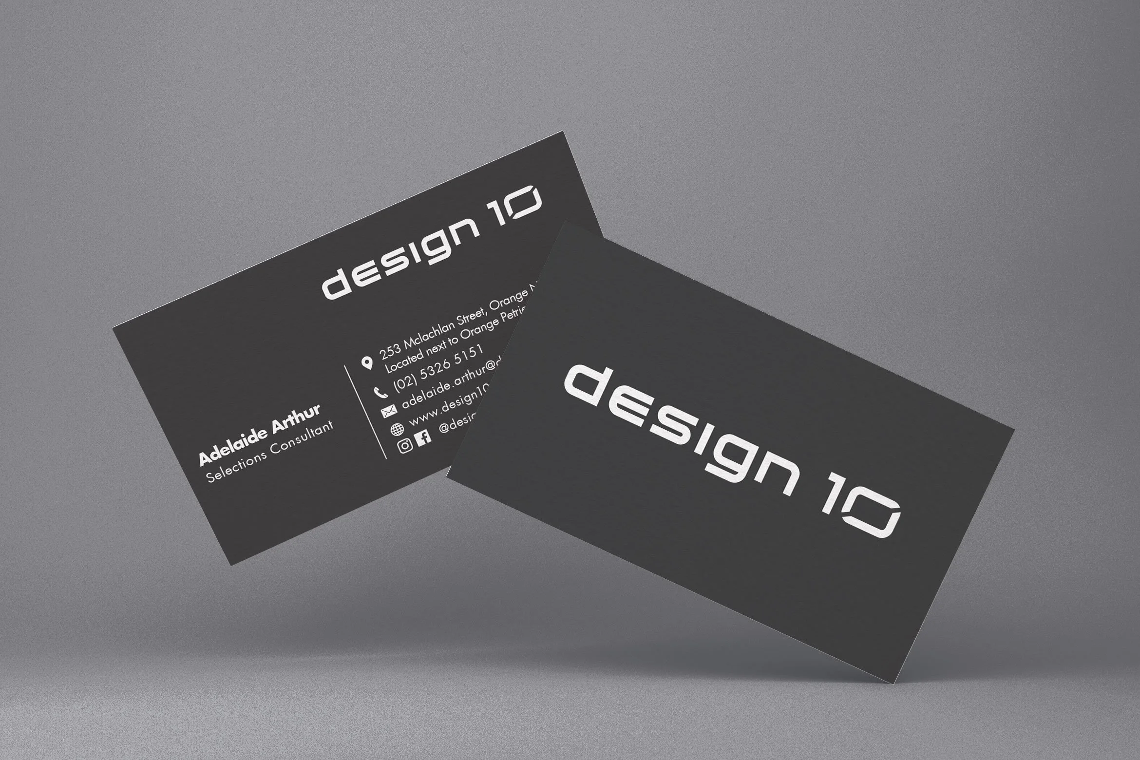Two black business cards for 'design 10' on a gray surface, one showing the front with the logo and the other displaying contact information for Adelaide Arthur, a selections consultant.