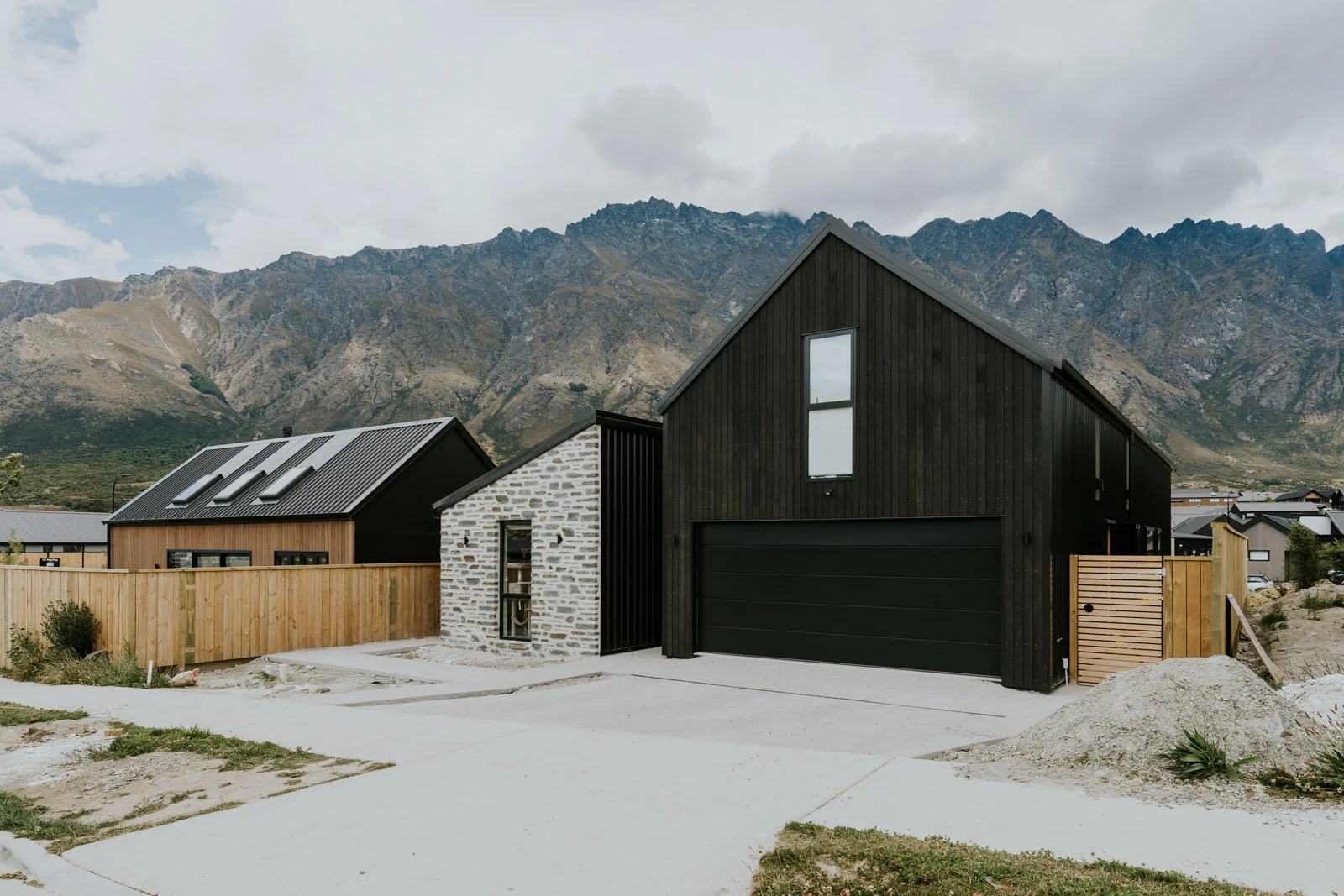 Modern black and white house with a mountain backdrop.