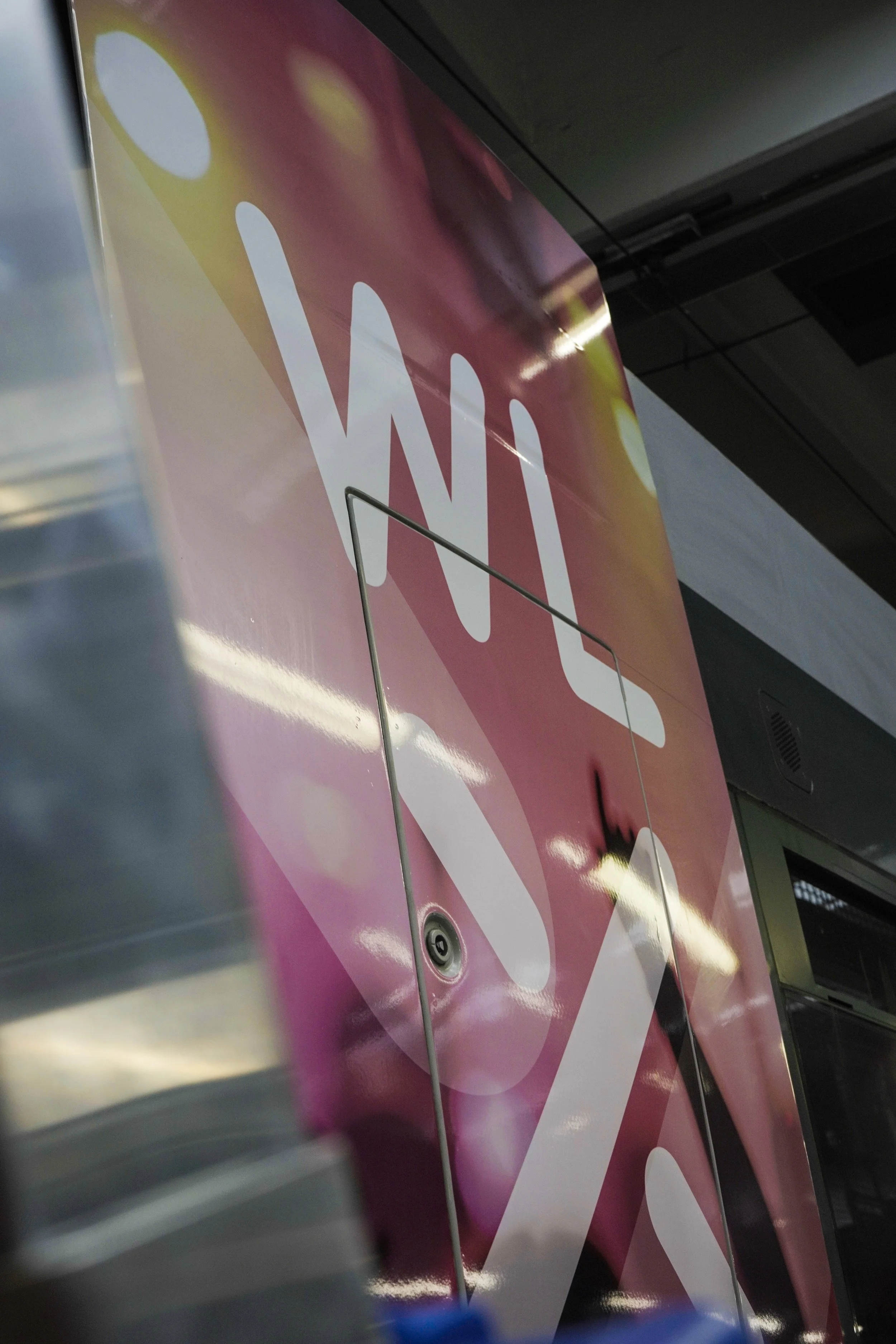 Close-up of a vending machine with the partial word "WILL" on a pink and orange background.
