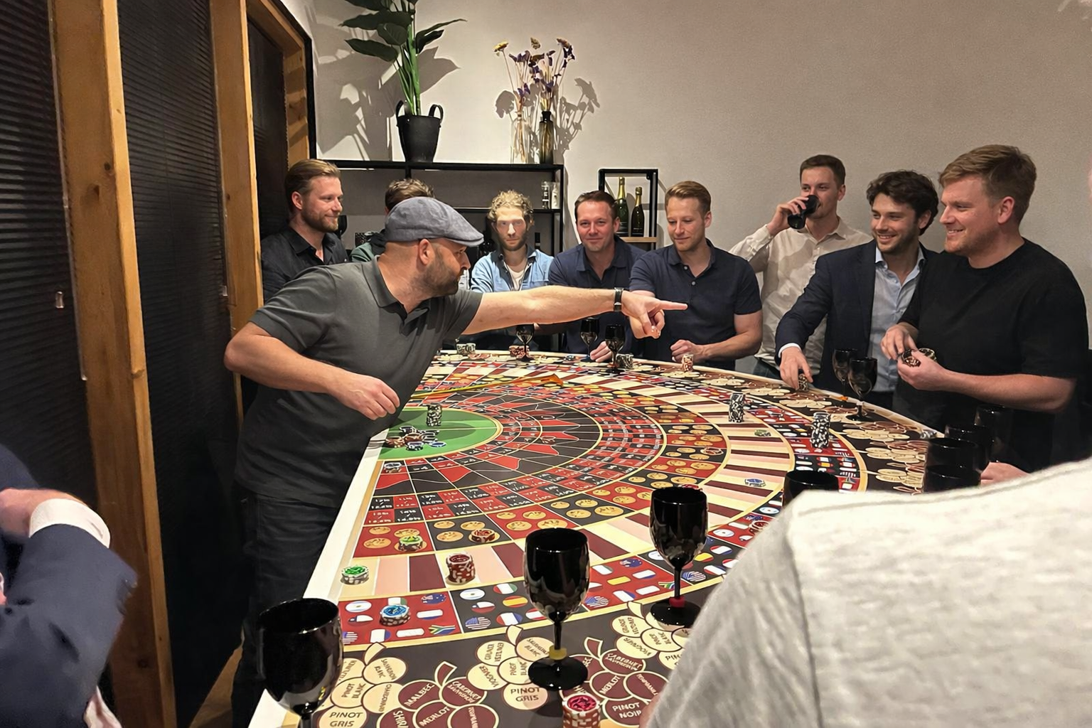 Mannen spelen roulette rond een tafel in een groepsfeest.