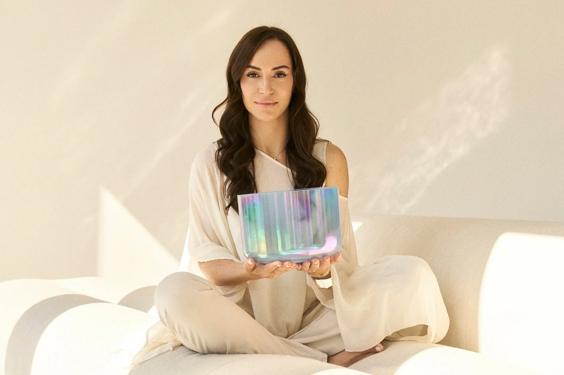 Sol Aragão holding a crystal singing bowl, founder of Resonance Sound Healing in Dubai