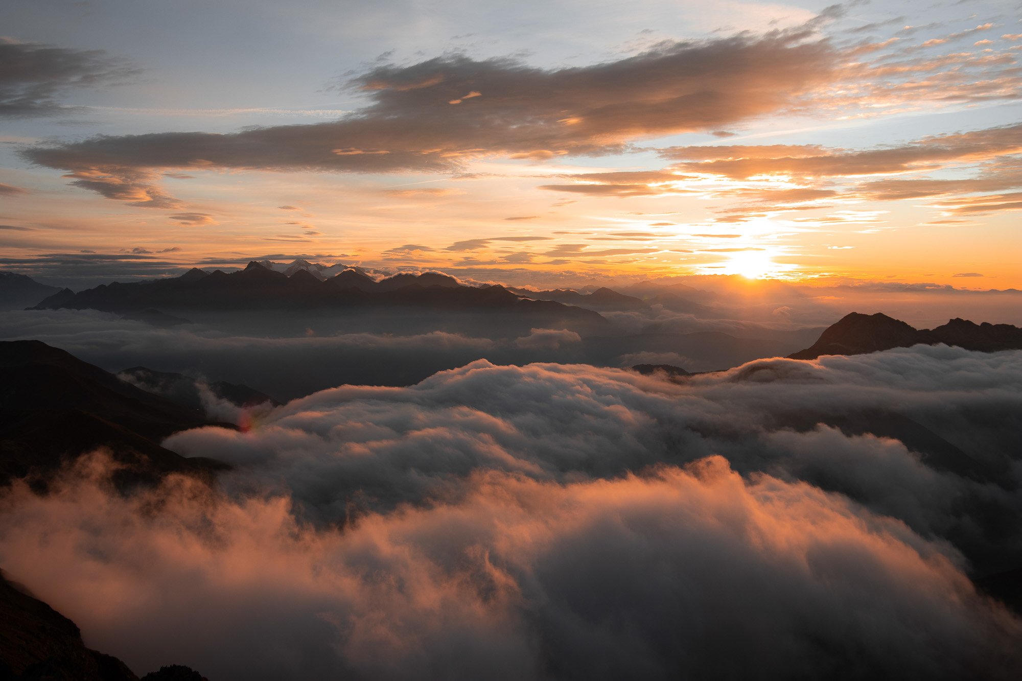 Berglandschaft bei Sonnenaufgang mit Wolken und Bergen im Hintergrund