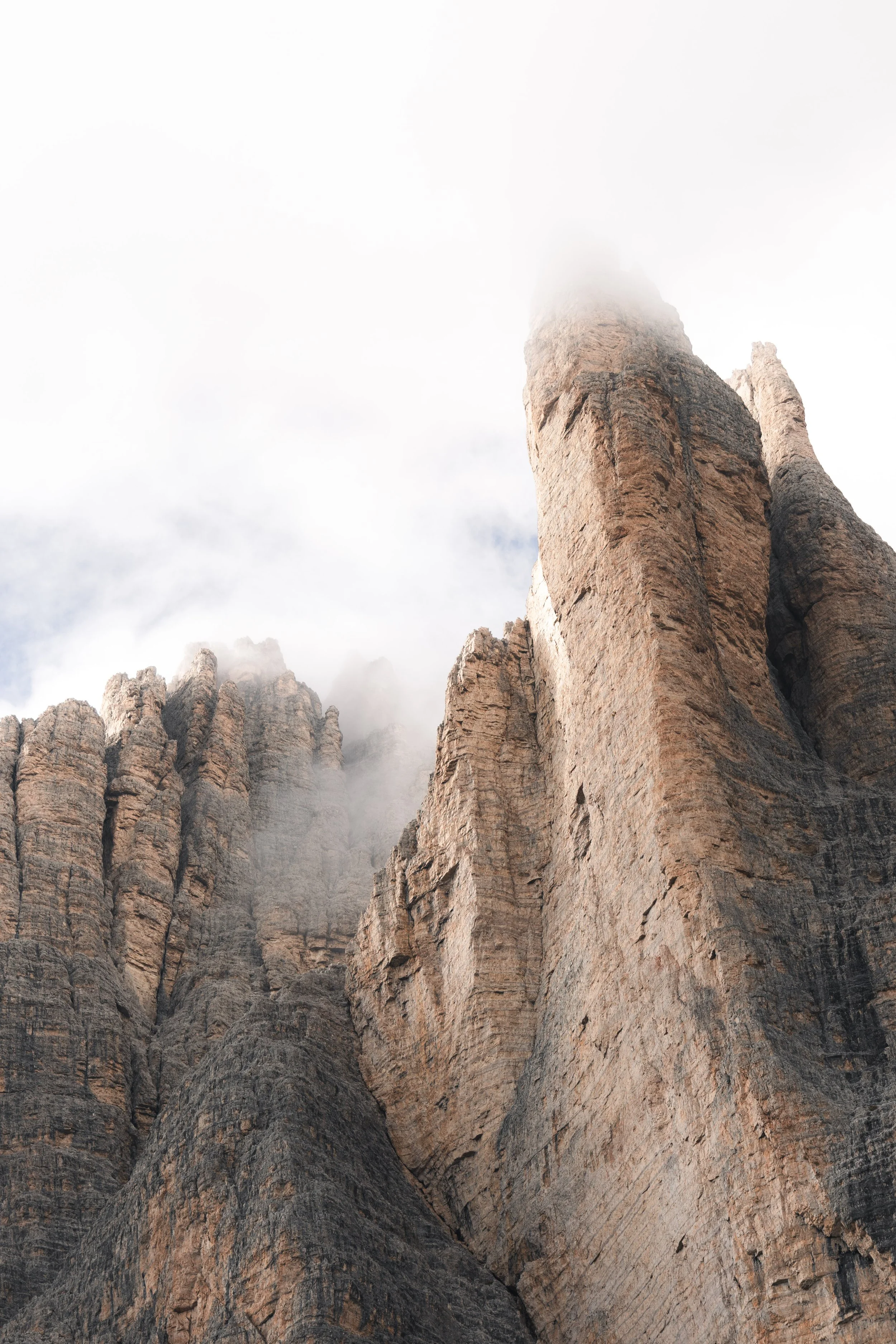 Felsformationen in den Bergen, teilweise von Wolken umhüllt.