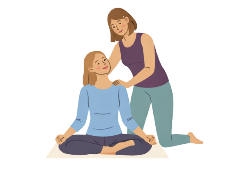 Eine Frau, die im Lotussitz auf einem Yoga- oder Meditationsmatte sitzt, während eine andere Frau neben ihr kniet und sie berührt.