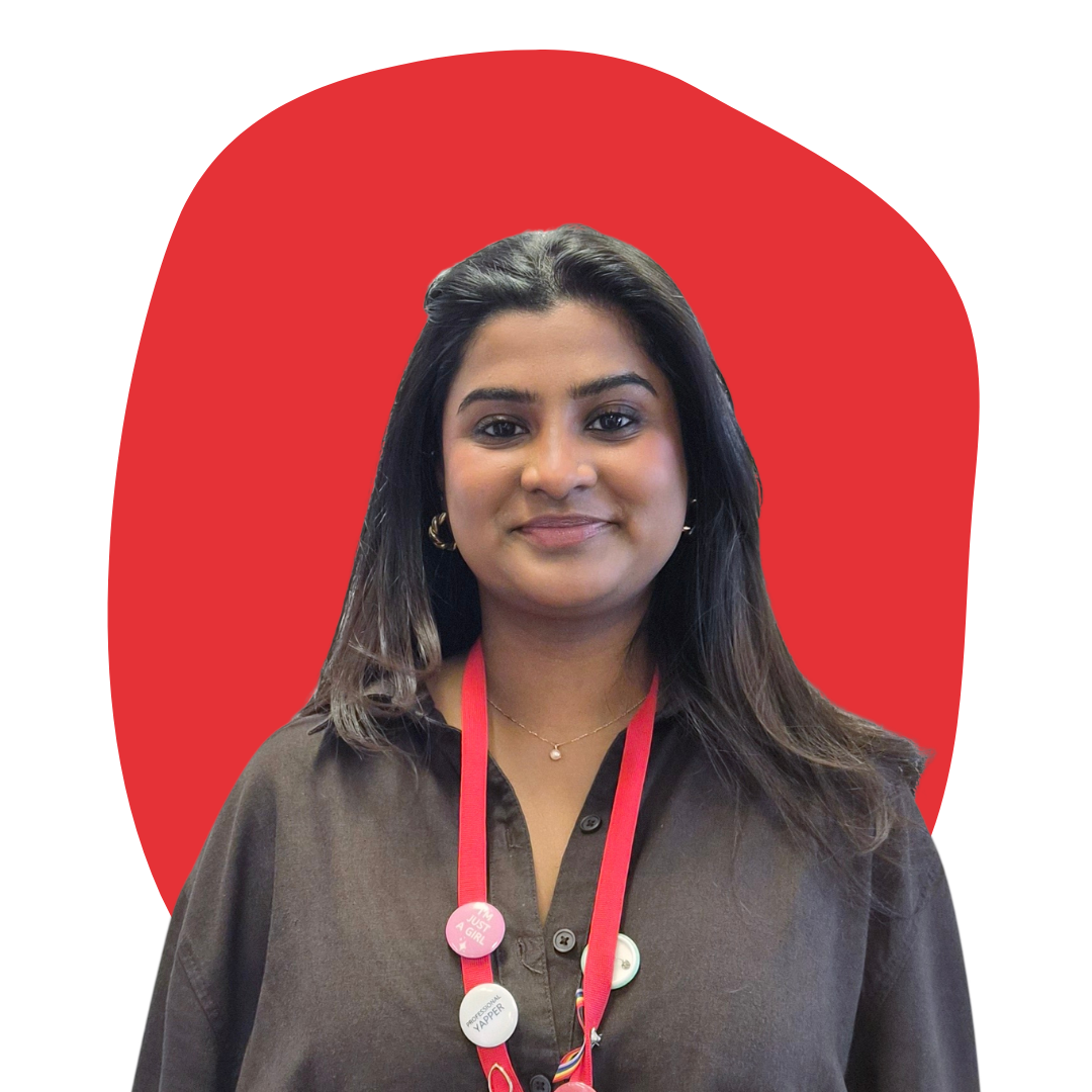 Portrait of a woman with dark hair, wearing a brown blouse and a red lanyard with buttons, set against a red, irregularly shaped background.