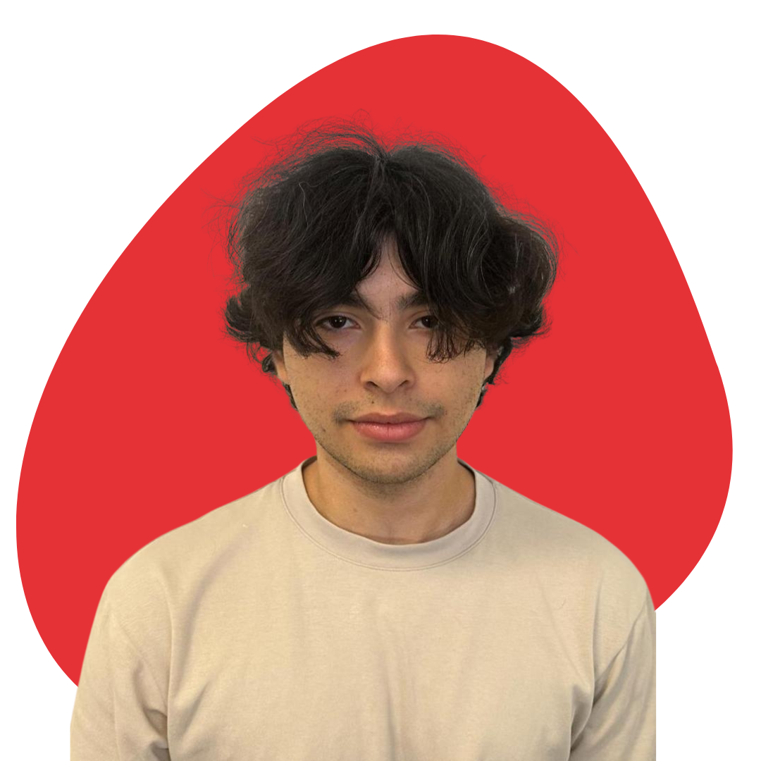 Young man with dark, curly hair and light skin, wearing a beige shirt, standing in front of a red abstract background.