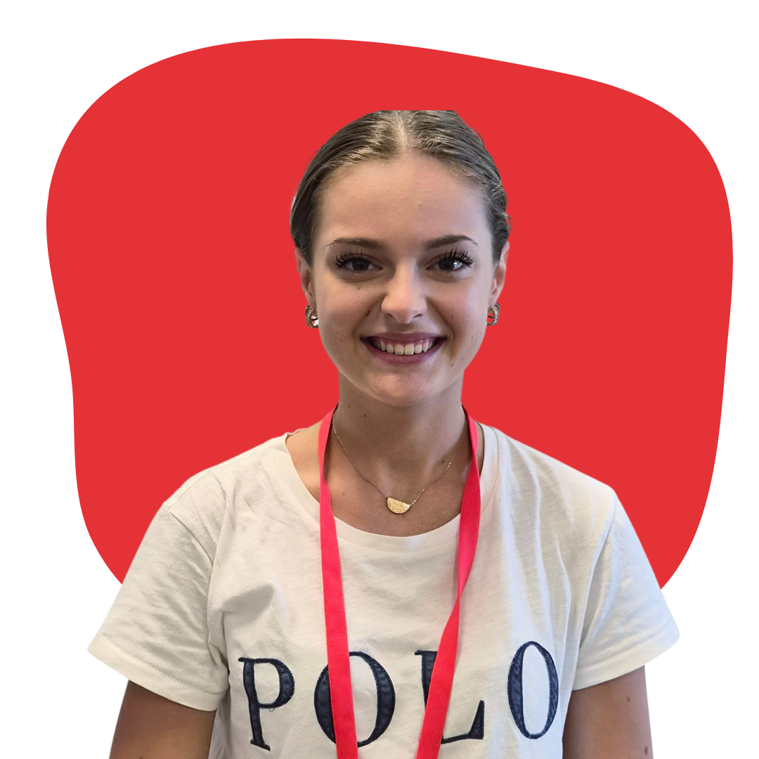 A young woman with brown hair smiling, wearing a white T-shirt with 'POLO' on it, gold jewelry, and a red lanyard, in front of a red background.