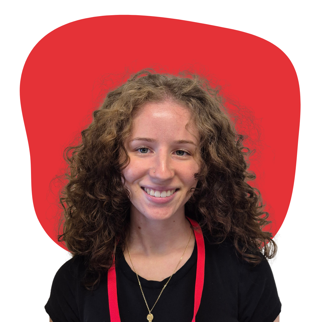 A smiling woman with curly hair in front of a red background.
