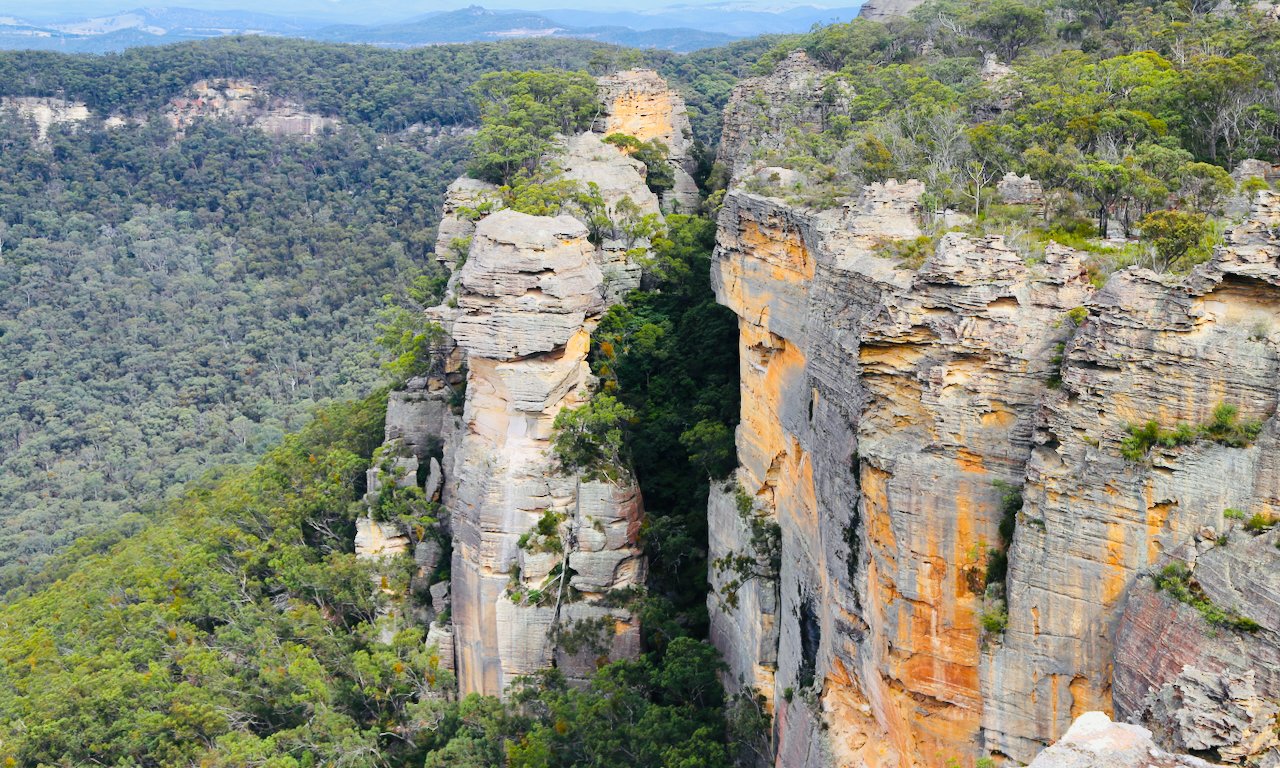 Cliff faces made of sandstone surrounded by green trees and dense forest.