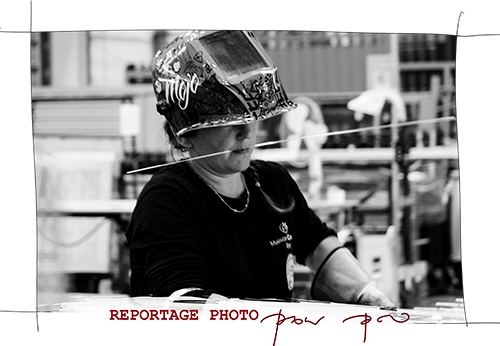 une femme soudeuse, visage concentre, un casque sur la tête. Image de JOhanne Gicquel photographe reportage pro bretagne