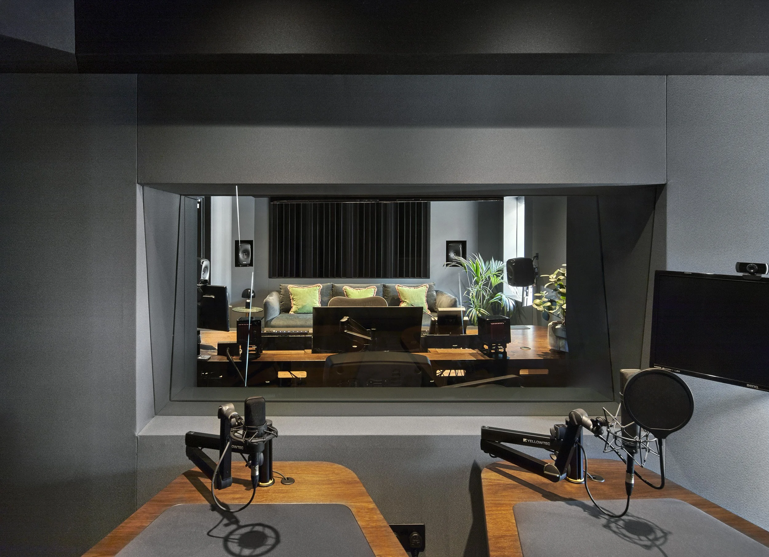Control room with monitors and mixing console for spatial immersive audio production.