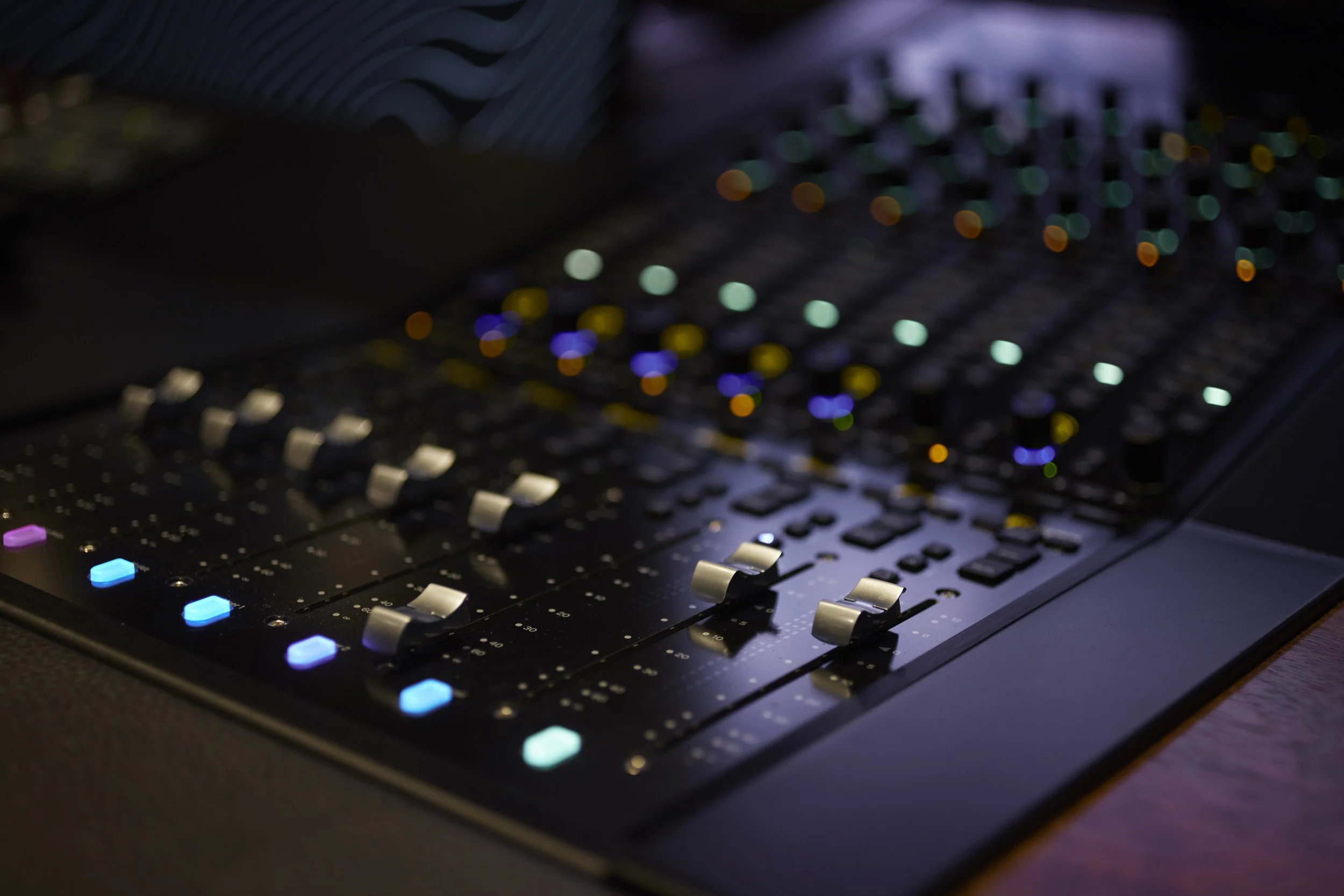 Dolby Atmos immersive audio workspace with surround speakers and mixing desk.