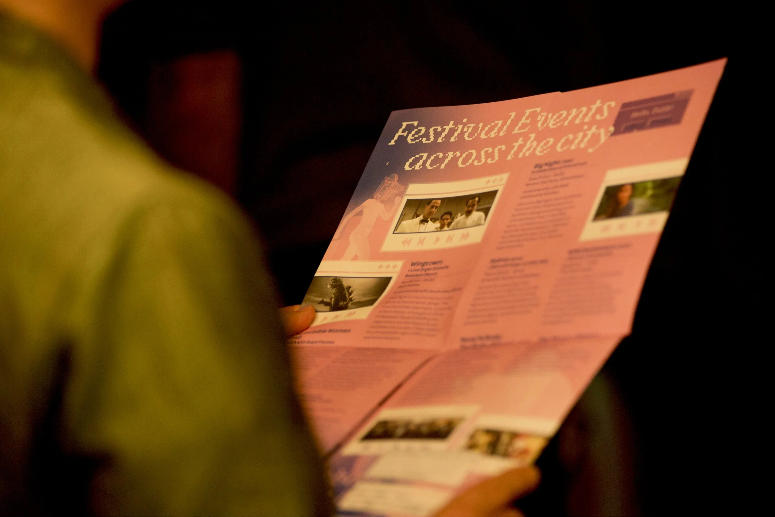 A guest reading the Festival Events Across the City leaflet.