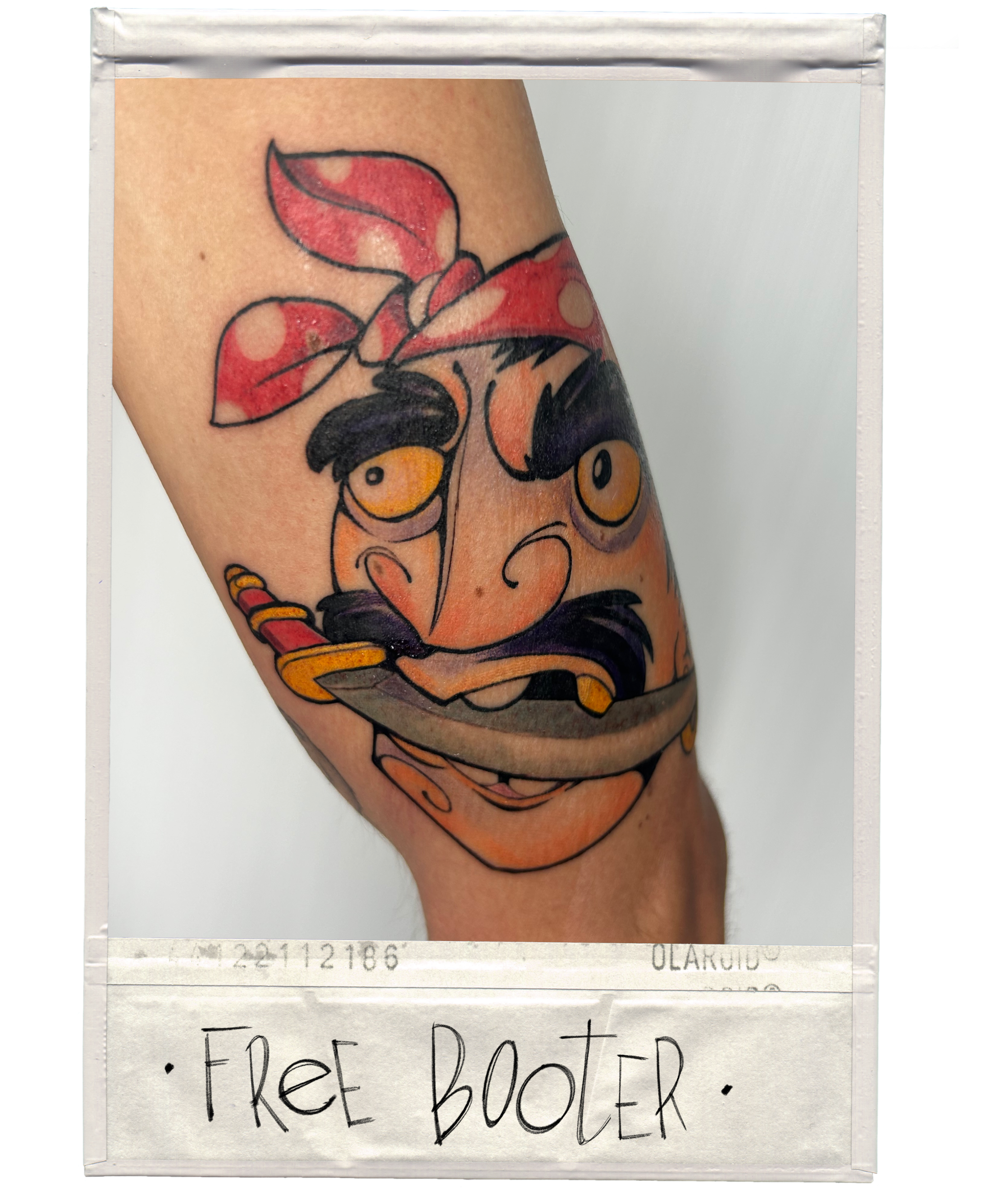 Tattoo of a cartoon character with a bandana, holding a knife, with the words 'FREE BOOTER' written below.