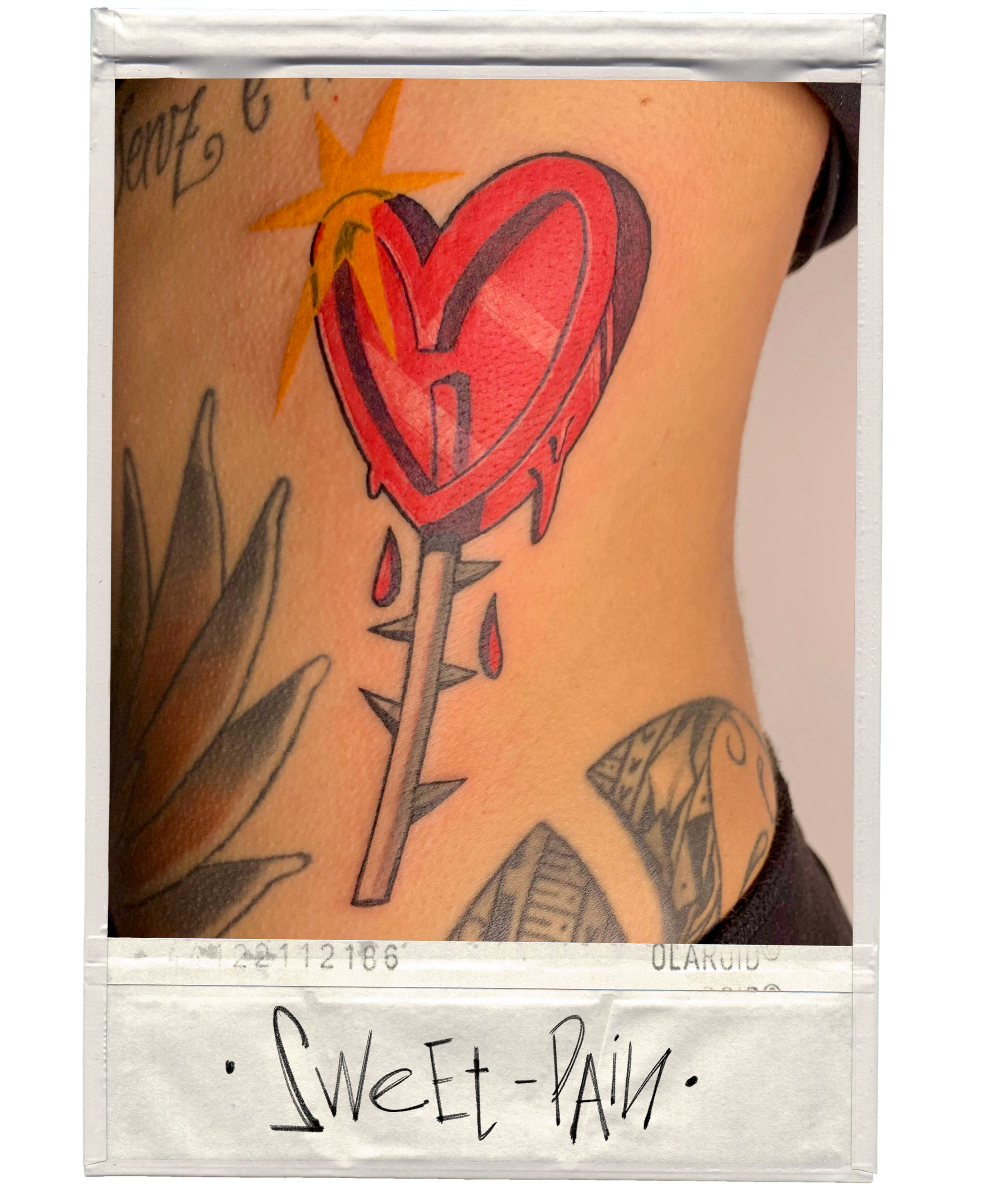 Tattoo of a dripping red heart with a knife through it, accompanied by a star and other tattooed designs on skin.