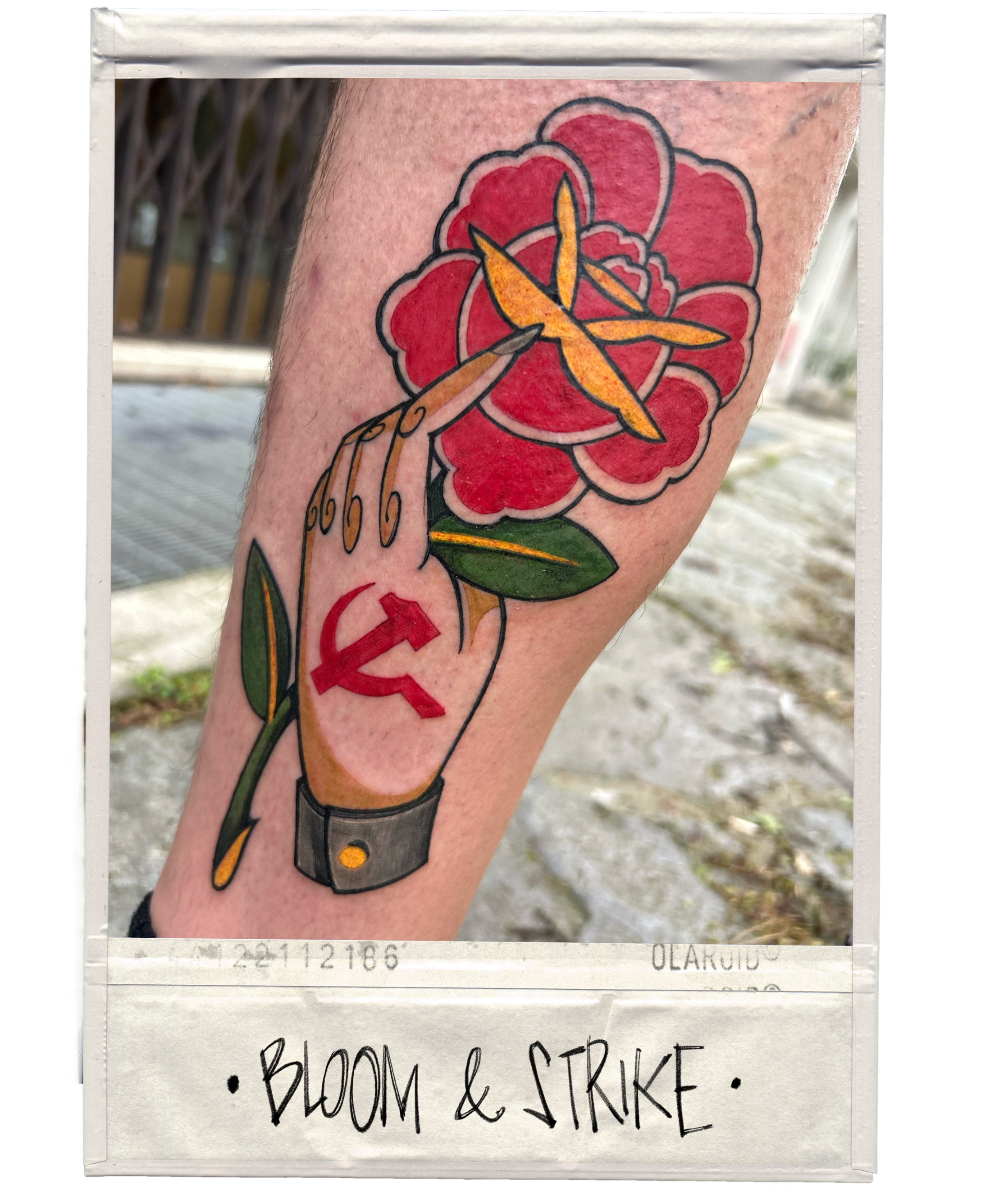 Tattoo of a hand holding a blooming red flower with a yellow interior and green leaves, with a red hammer and sickle symbol on the wrist, labeled 'Bloom & Strike'.