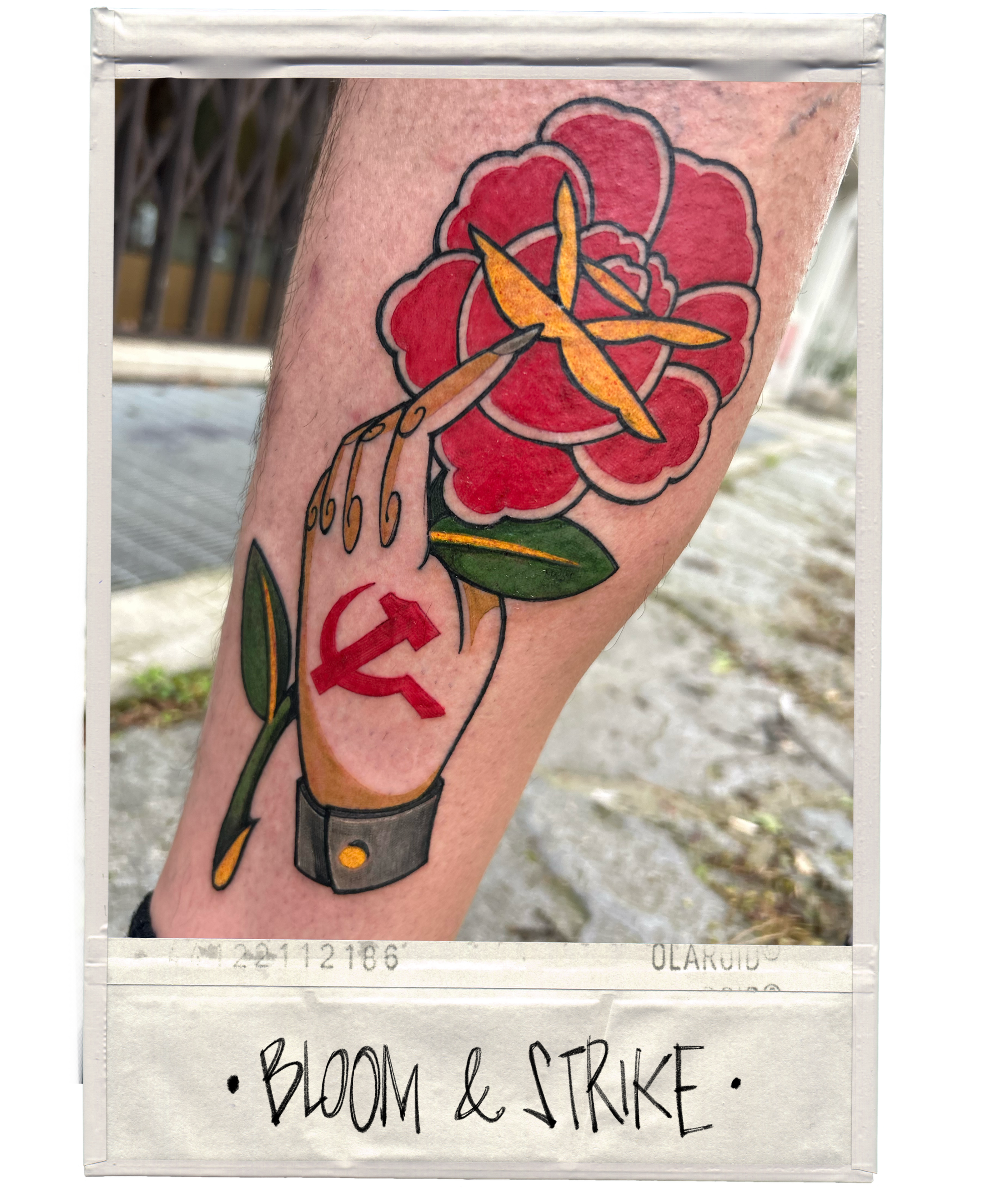 Tattoo of a hand holding a blooming red flower with yellow accents, a green leaf, a black bracelet, and a red hammer and sickle symbol on the forearm, with the words "BLOOM & STRIKE" written below.