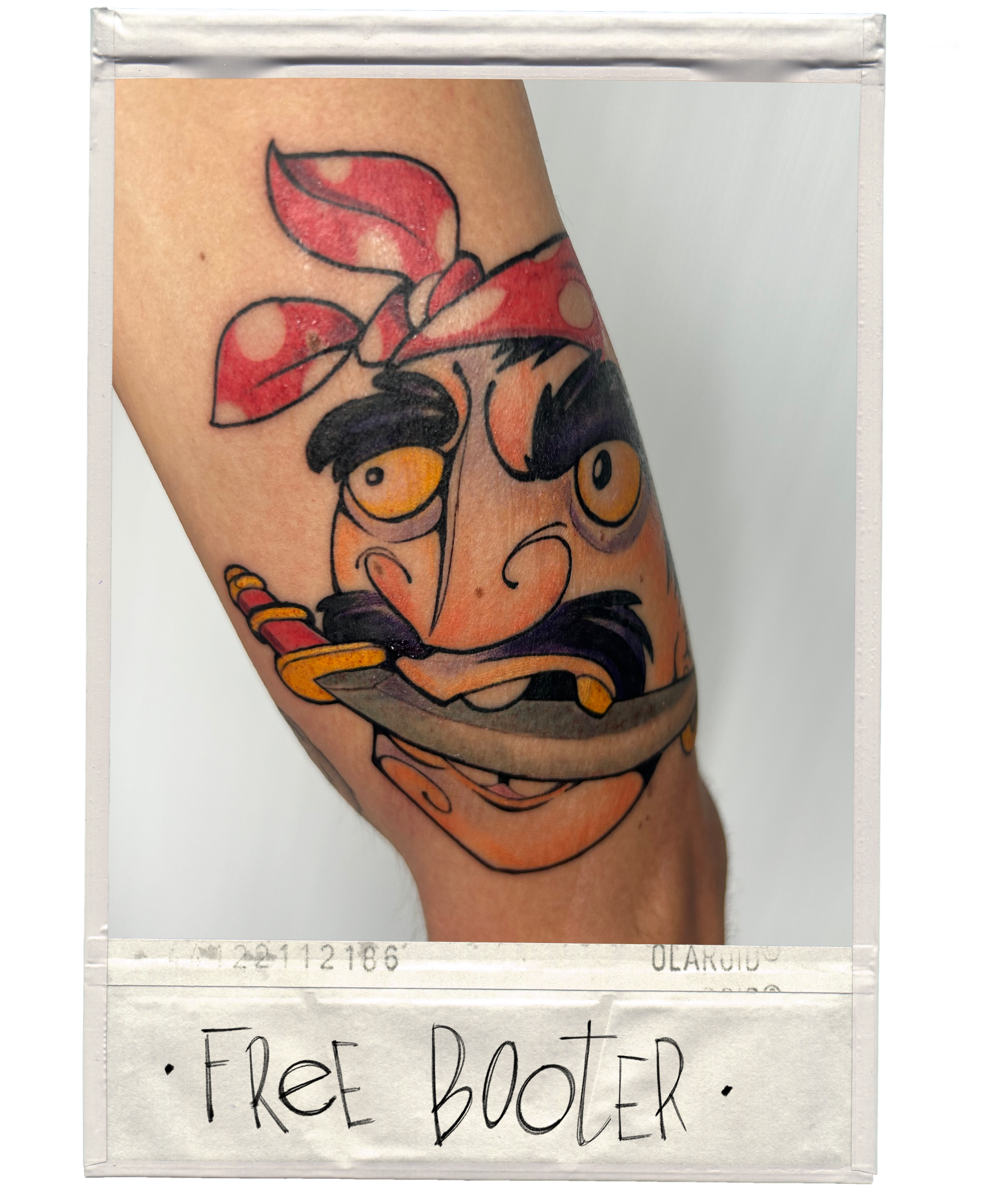 Tattoo of a cartoon character with a bandana, holding a knife, with the words 'FREE BOOTER' written below.