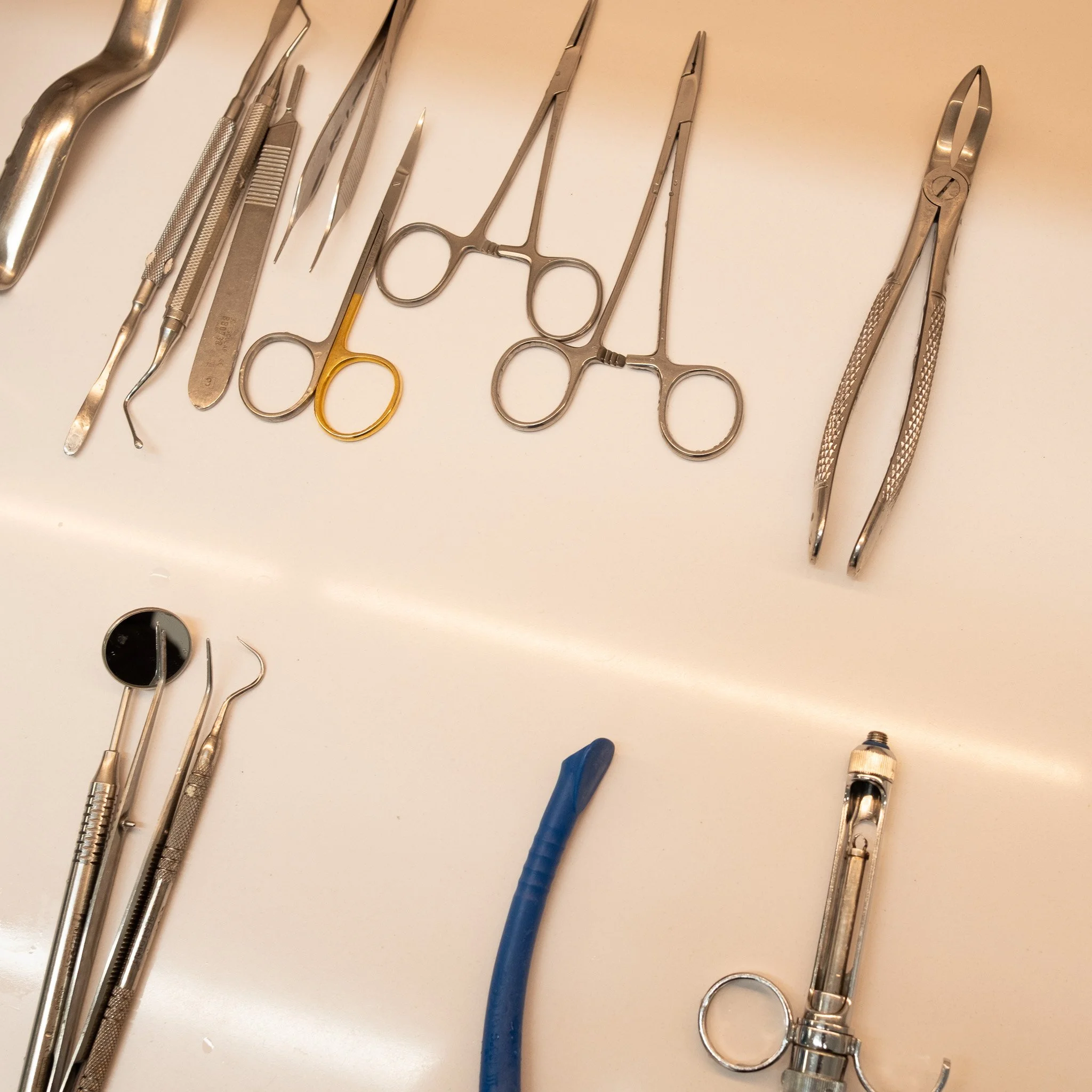 Instrumentos dentales y herramientas médicas sobre una mesa blanca.