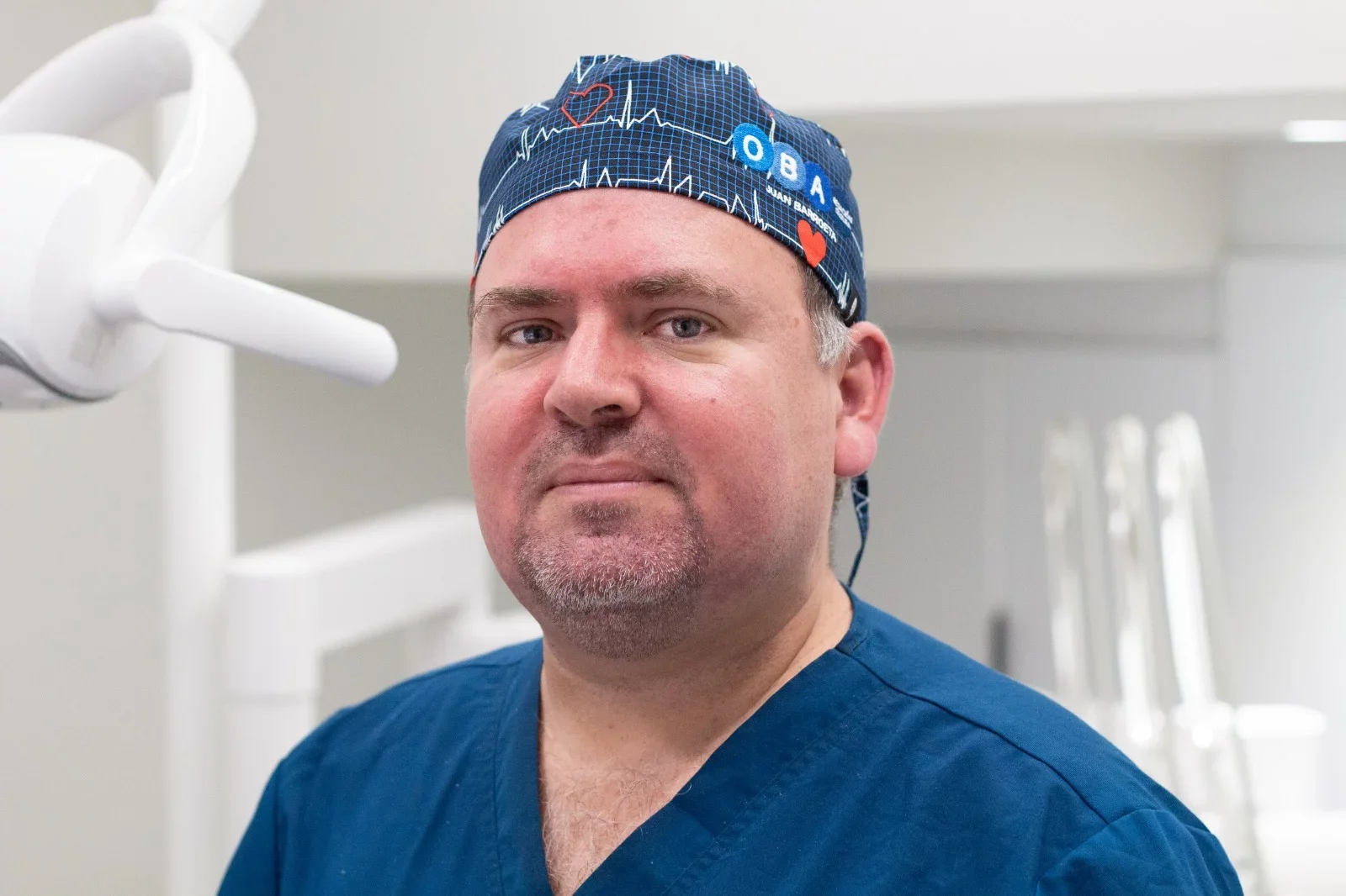 Un hombre con uniforme de médico y gorra hospitalaria en una clínica u hospital.