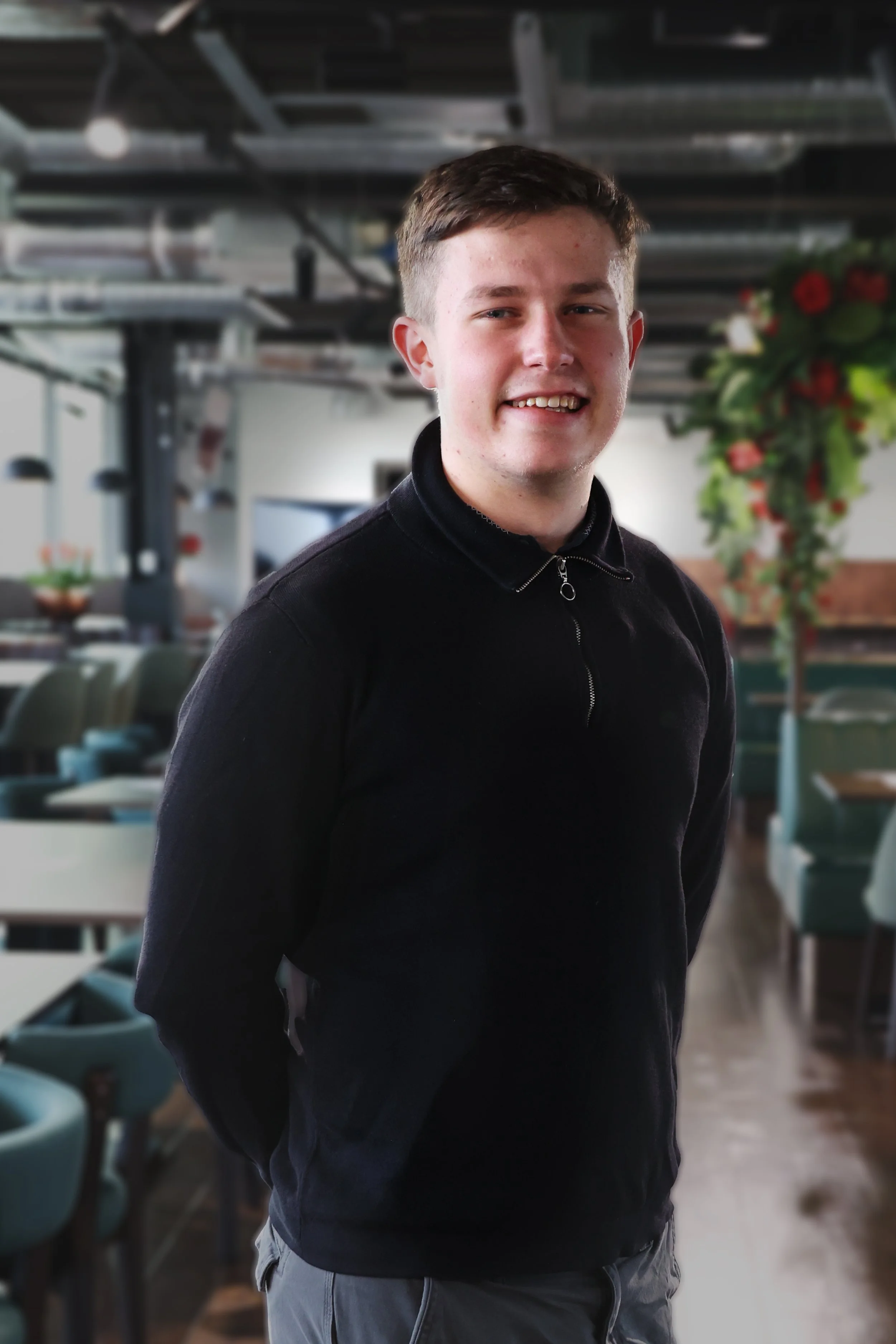 Simon Reynolds headshot in black quarter zip smiling indoors.