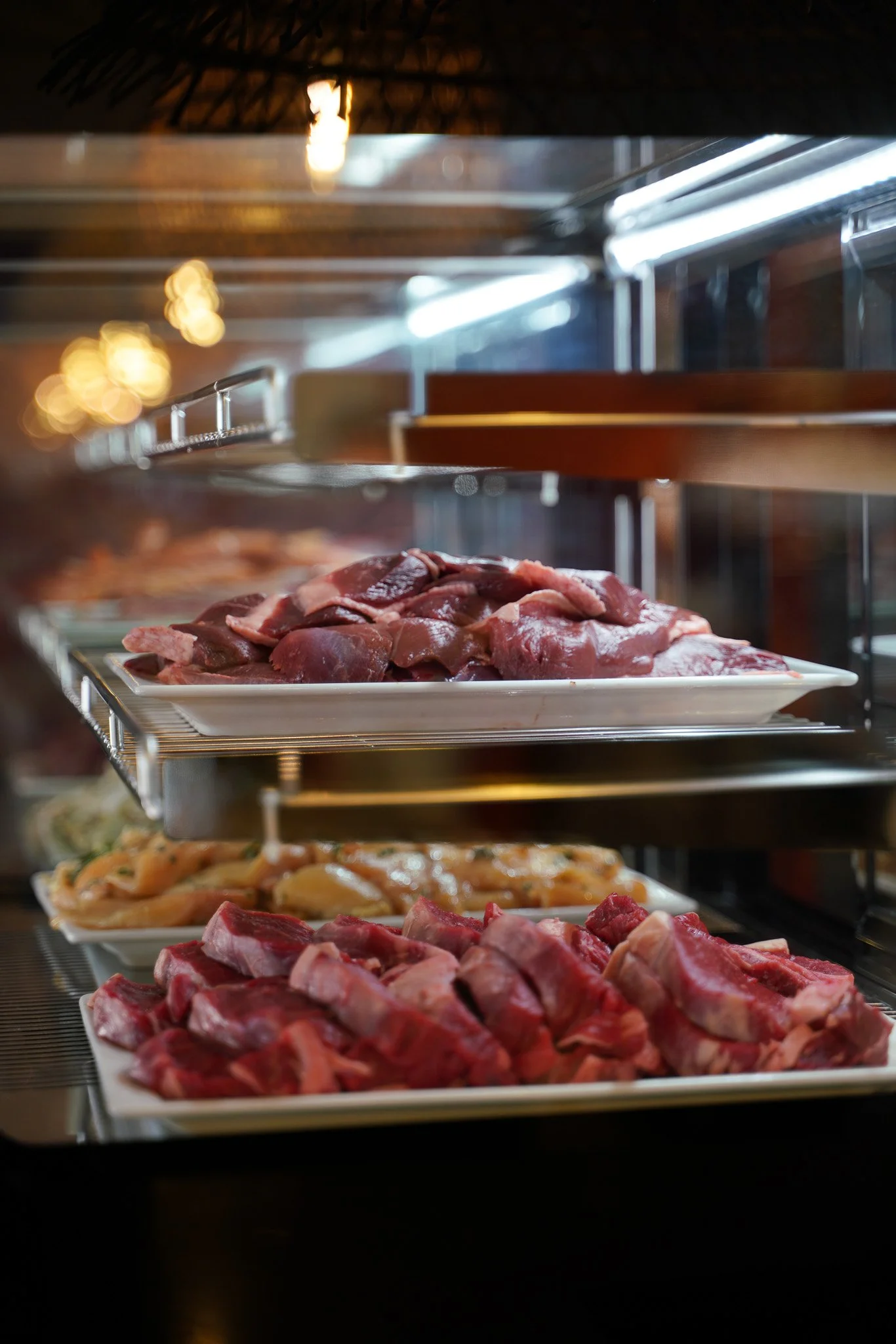 Viandes rouges française disposées sur des plateaux dans une vitrine réfrigérée - Les Buffets de l'Eden
