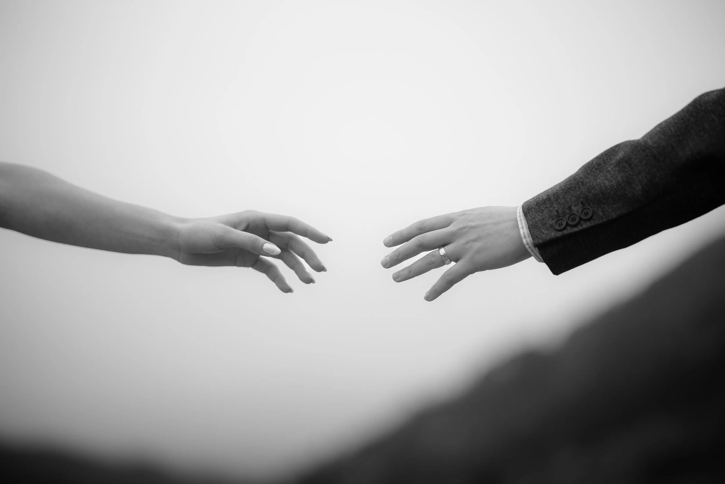 Bride and groom reaching for each other during intimate elopement in the Scottish Highlands