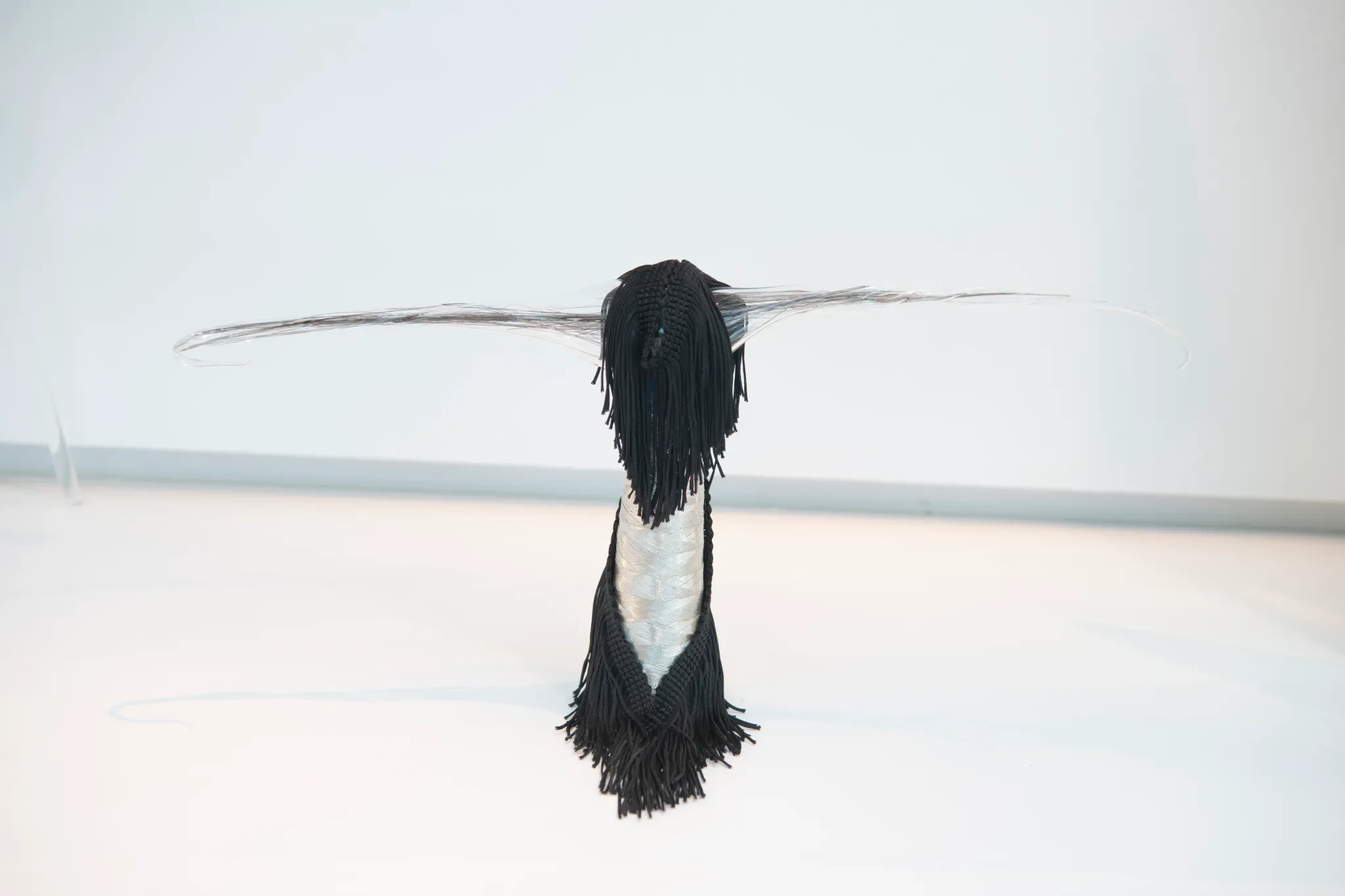 Salvaged glass, glass ‘hair’, tassel fringe, thread spool