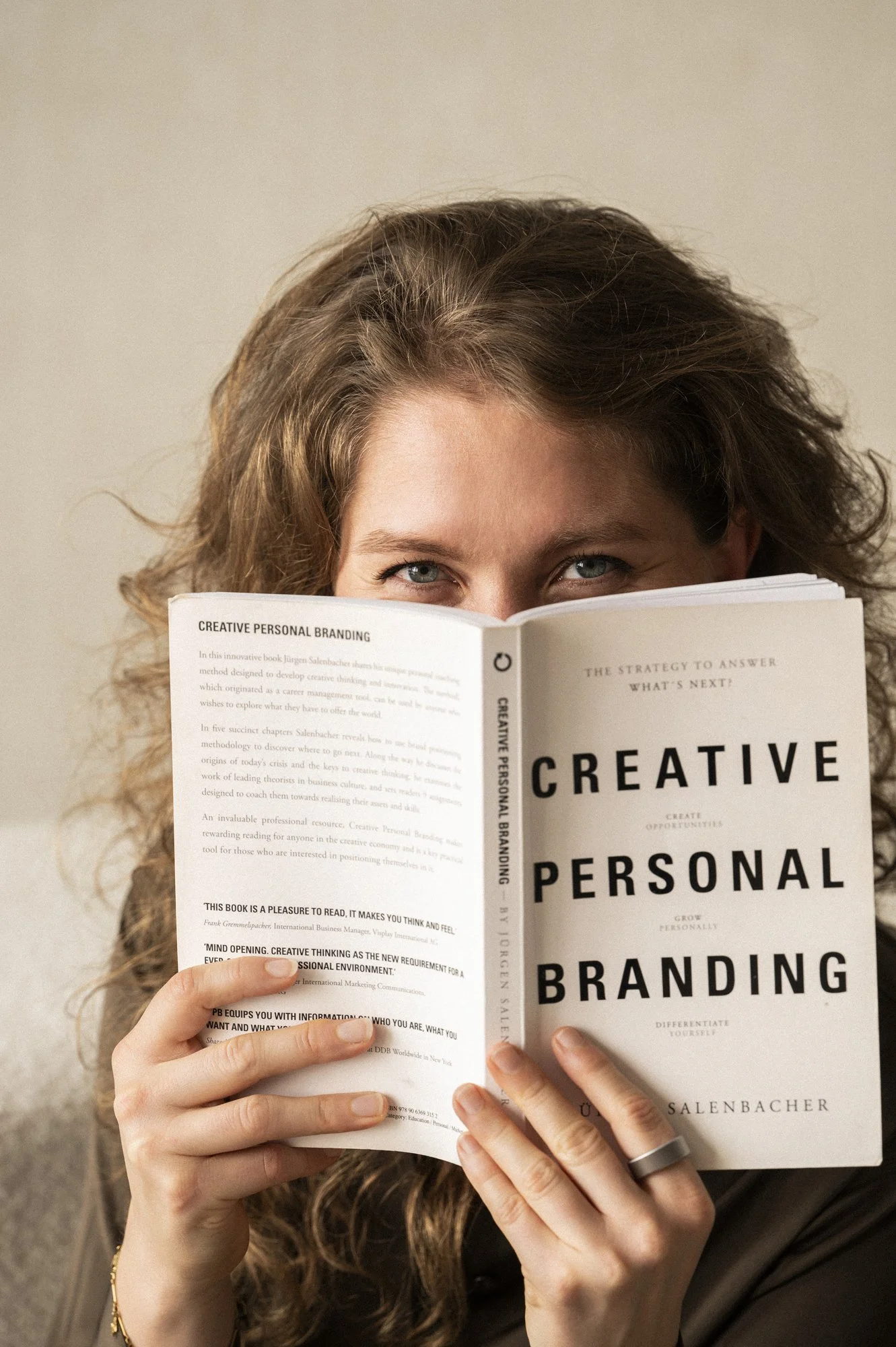 Vrouw met lang, golvend haar leest een boek over persoonlijke branding.