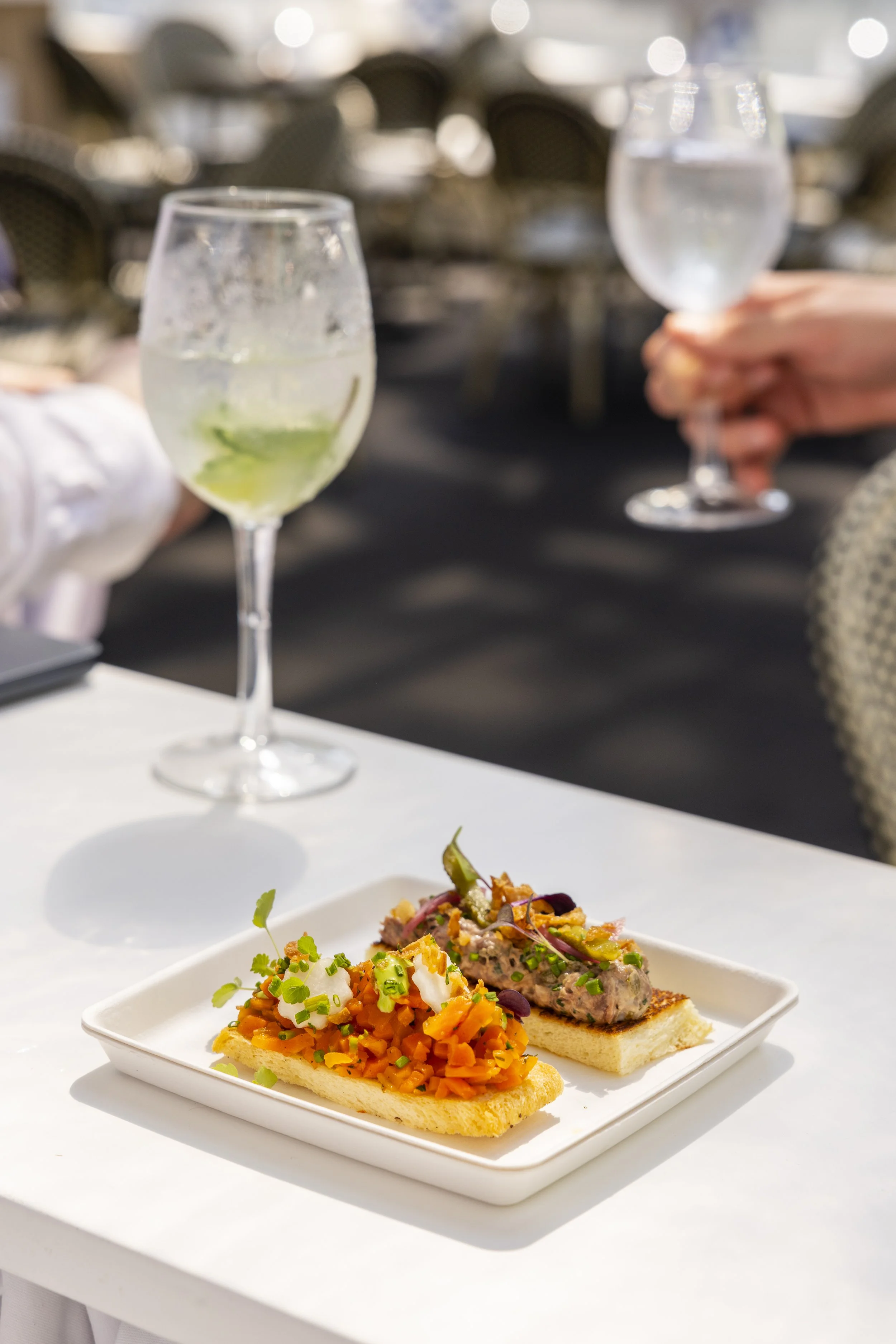 Een bord met twee tapas: een met gerookte vis en een met een groenteragout.