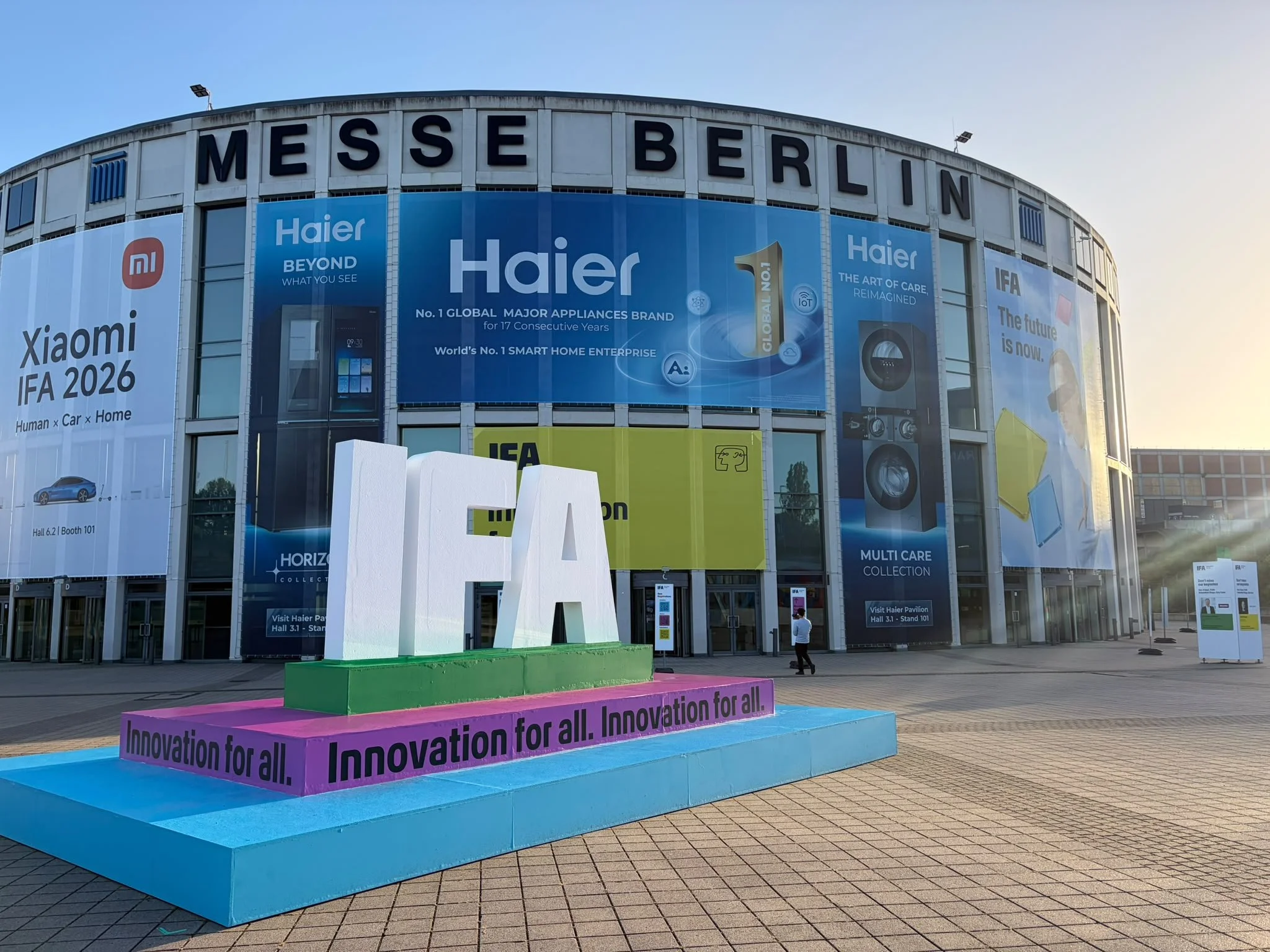 Exterior of Messe Berlin convention center with large colorful banners promoting innovation and technology brands at the IFA 2024 event.
