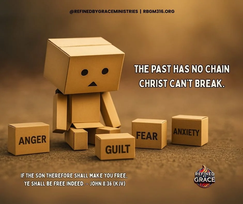 A small cardboard robot sitting on the ground surrounded by cardboard blocks labeled 'ANGER,' 'GUILT,' 'FEAR,' and 'ANXIETY.' The robot has a simple face with two small circles for eyes and a small triangle for a mouth. There is a Bible verse at the bottom of the image from John 8:36, and the text 'The past has no chain Christ can't break' is on the right side.