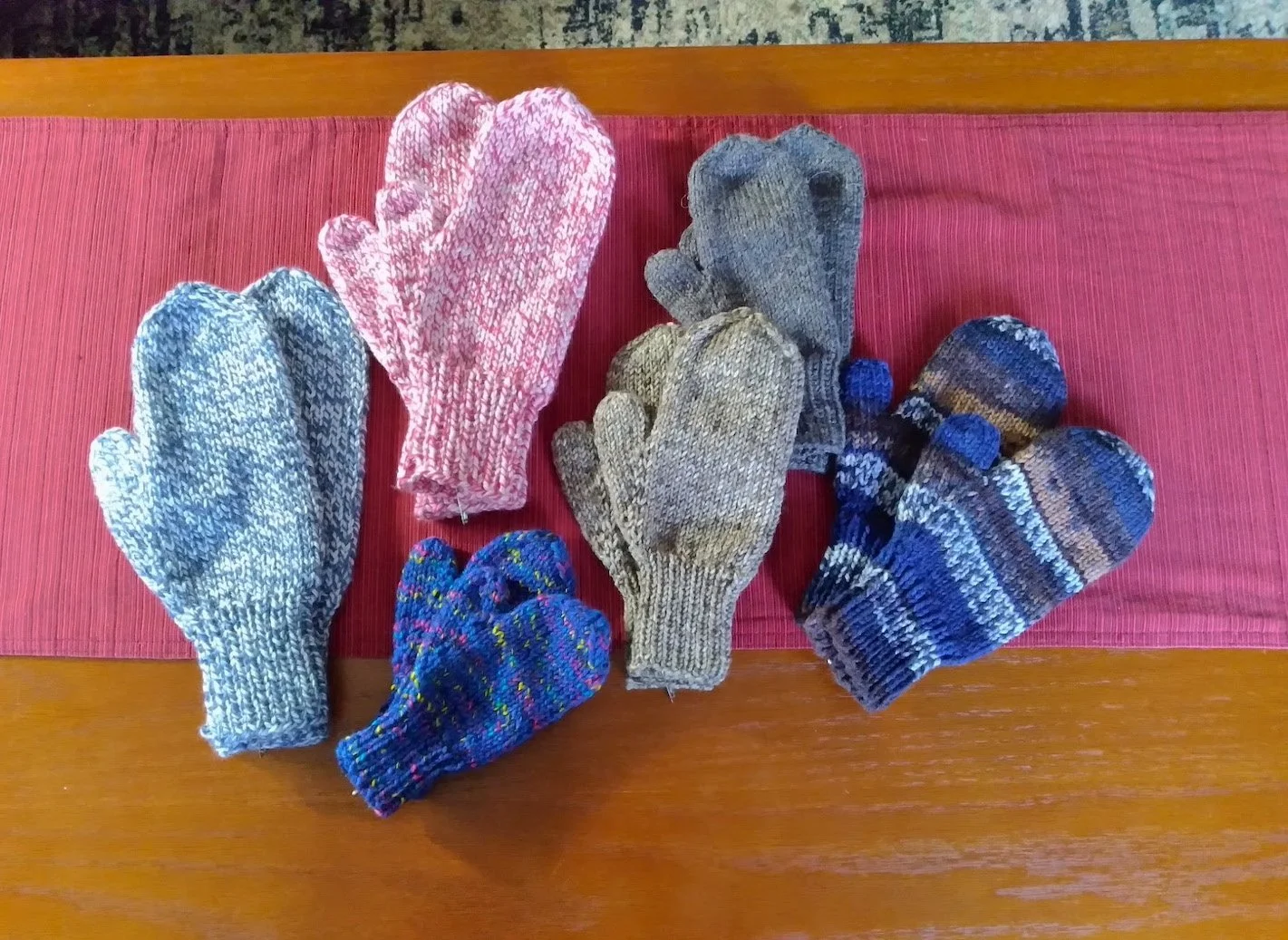 Six pairs of handknit mittens