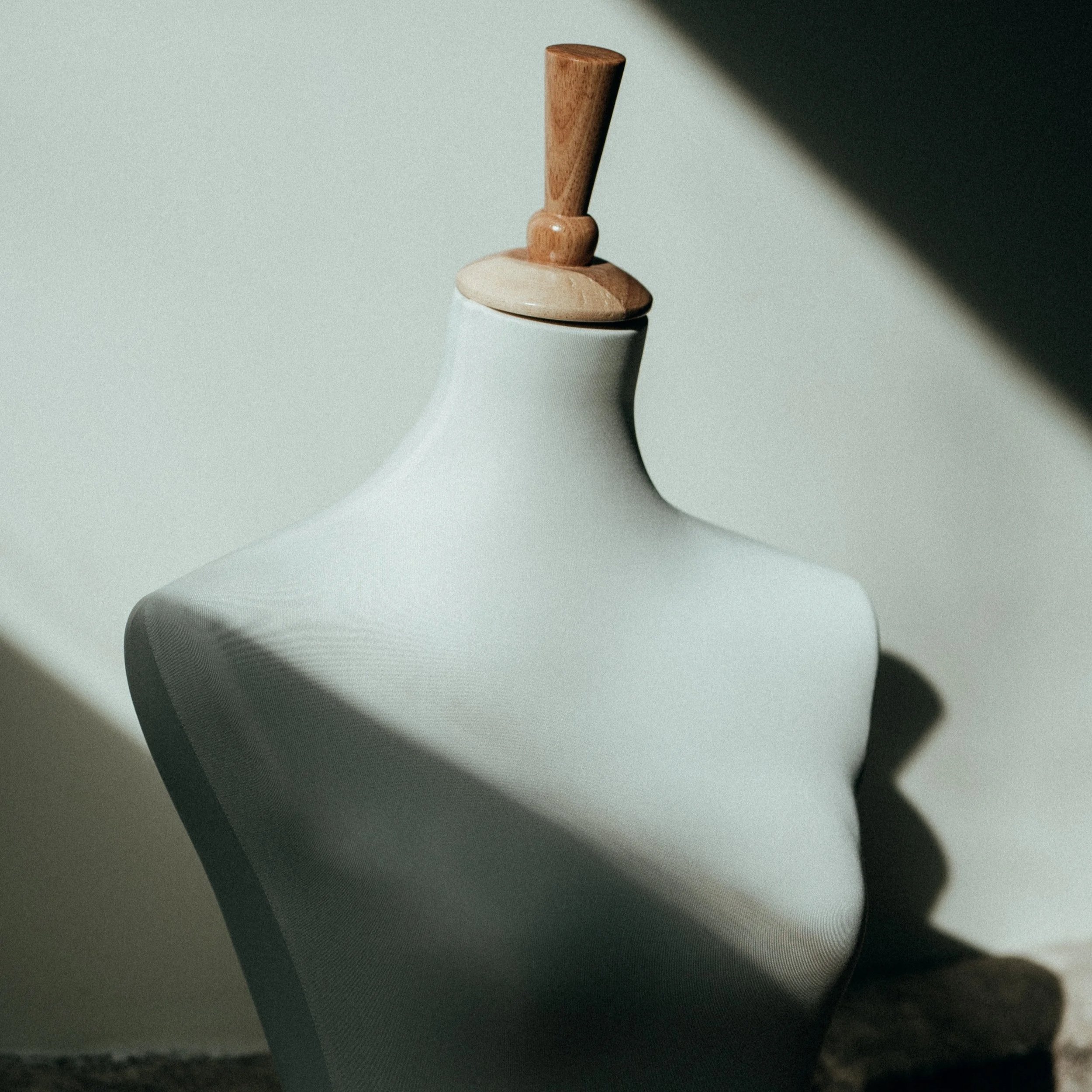 Mannequin blanc, éclairé par la lumière naturelle, créant une ombre contrastée.