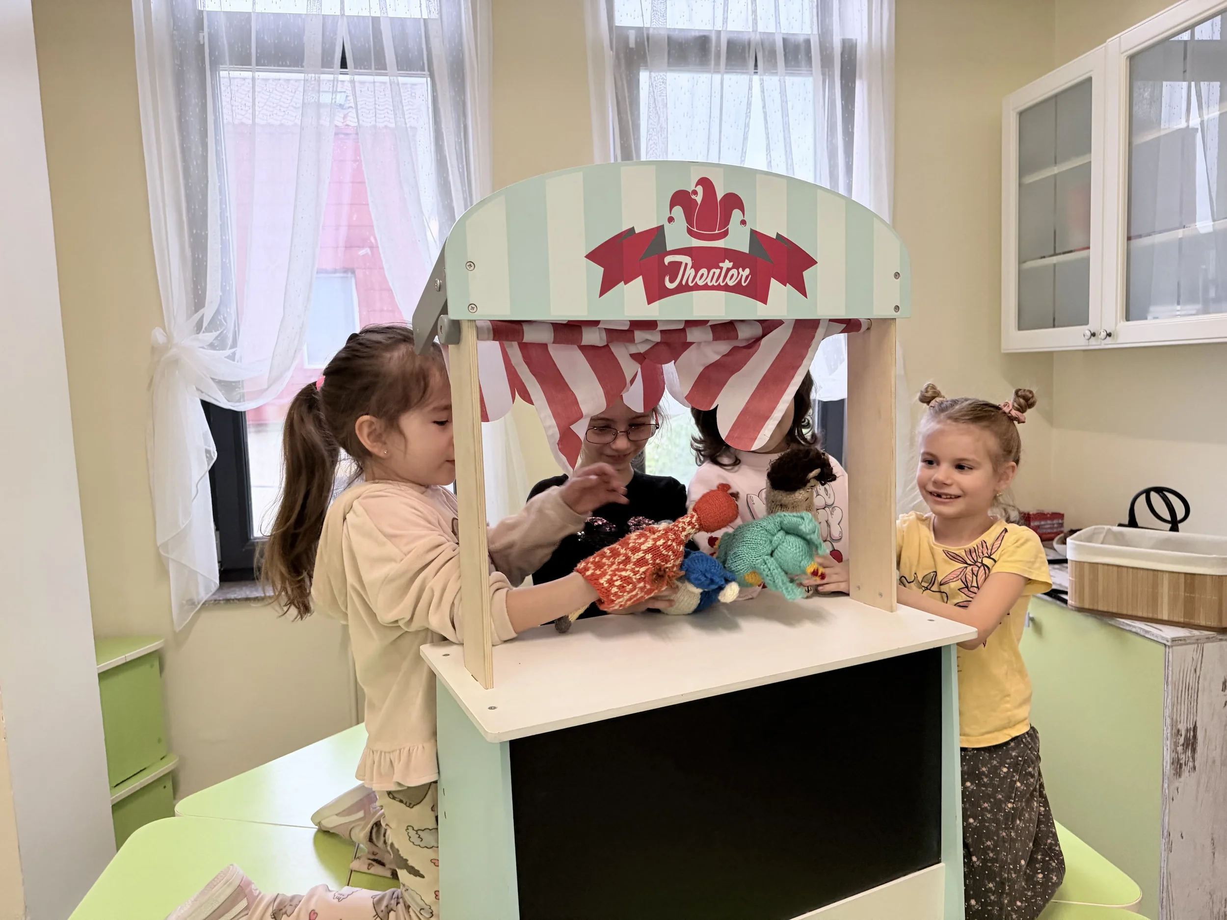 Copii zâmbitori participând la jocuri de rol și teatru de păpuși pentru învățarea interactivă a limbilor străine la York Rose Language School Constanța.