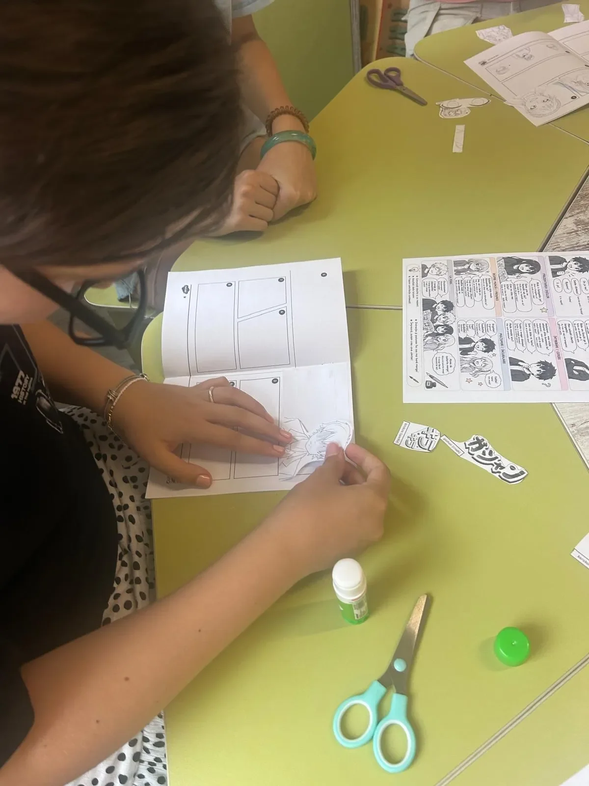 Elevă lucrând la propria bandă desenată manga în timpul atelierului practic de japoneză